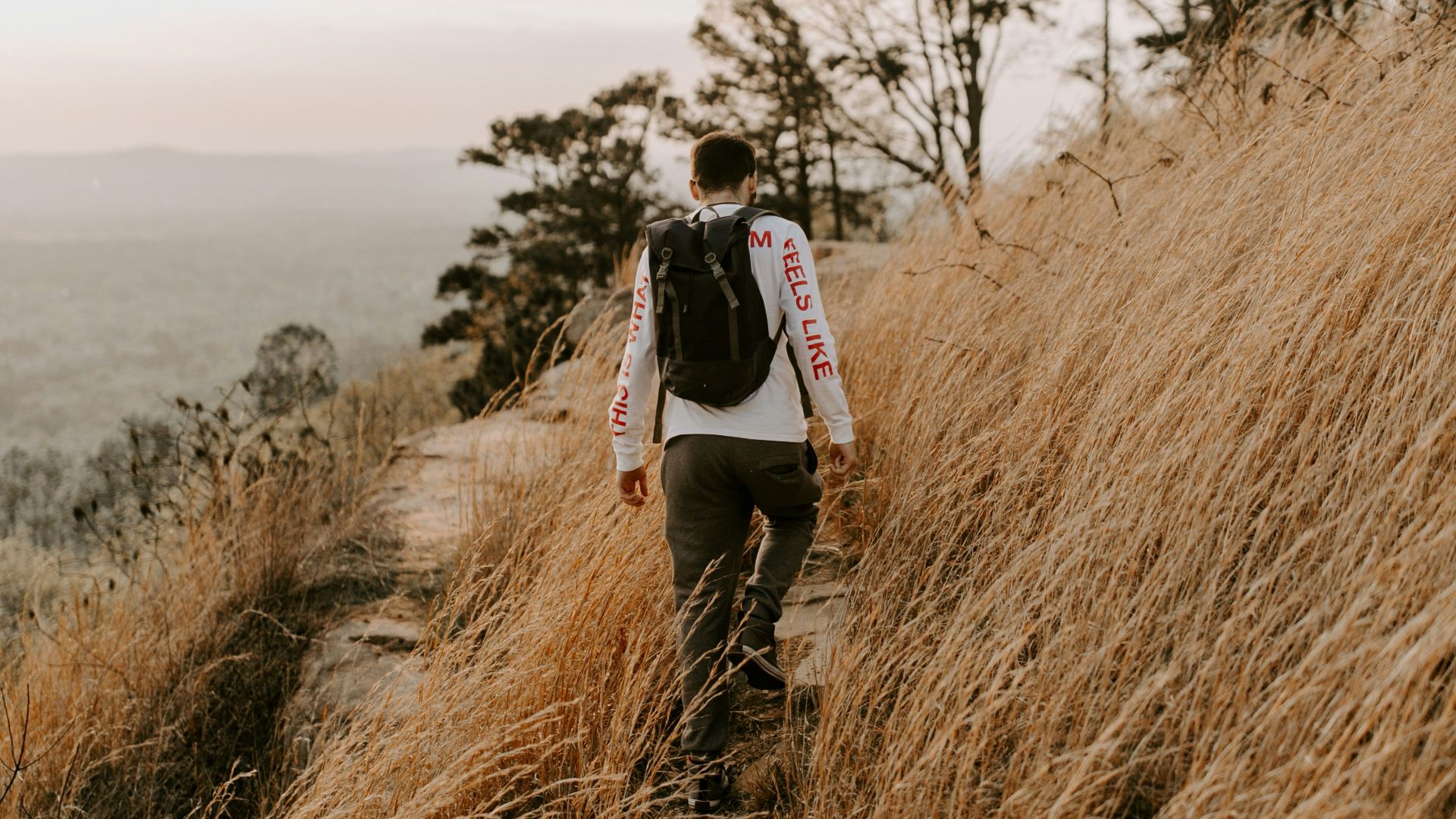 woman in black jacket standing on brown grass field during daytime