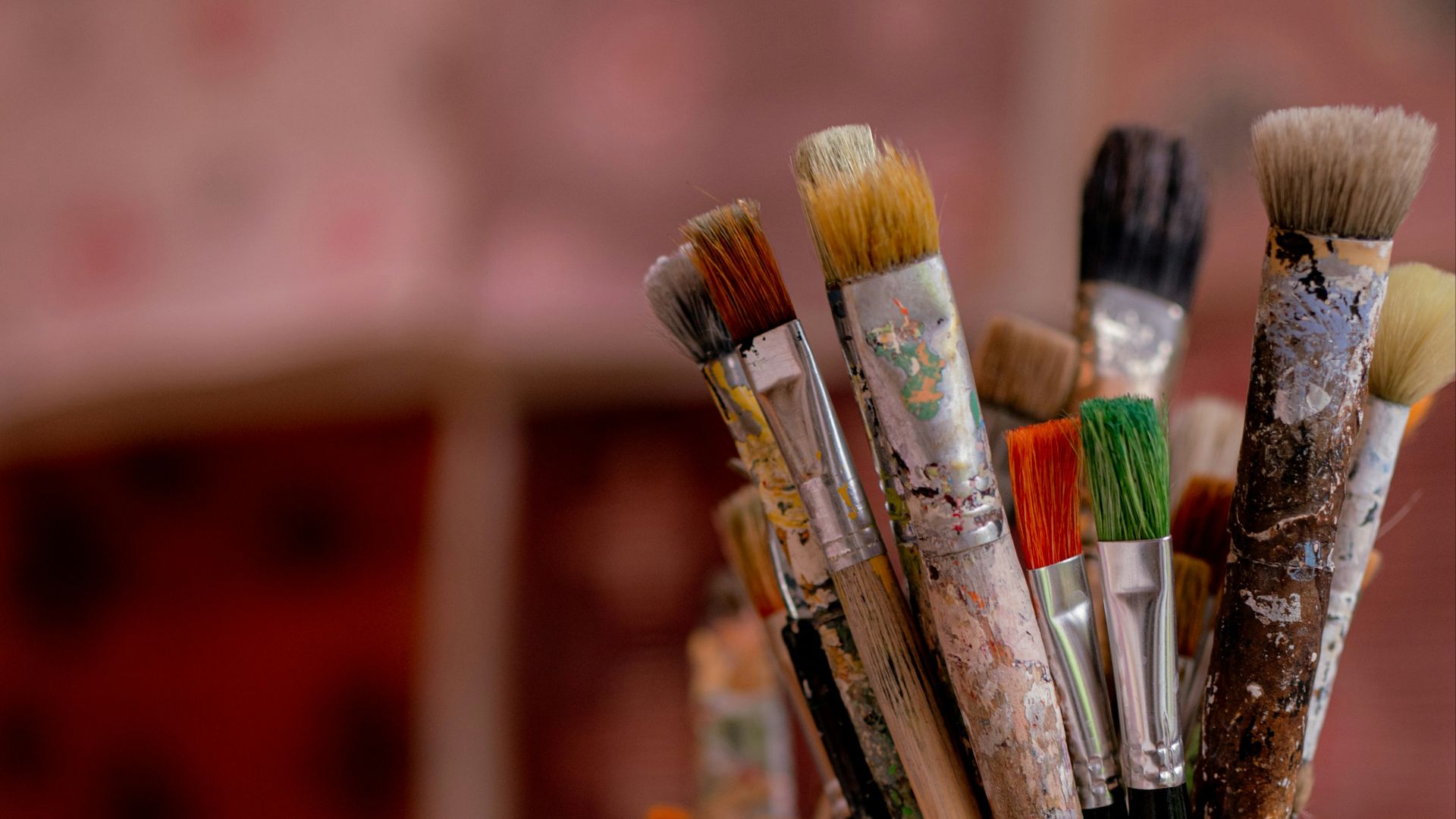 brown and red paint brush in clear glass container