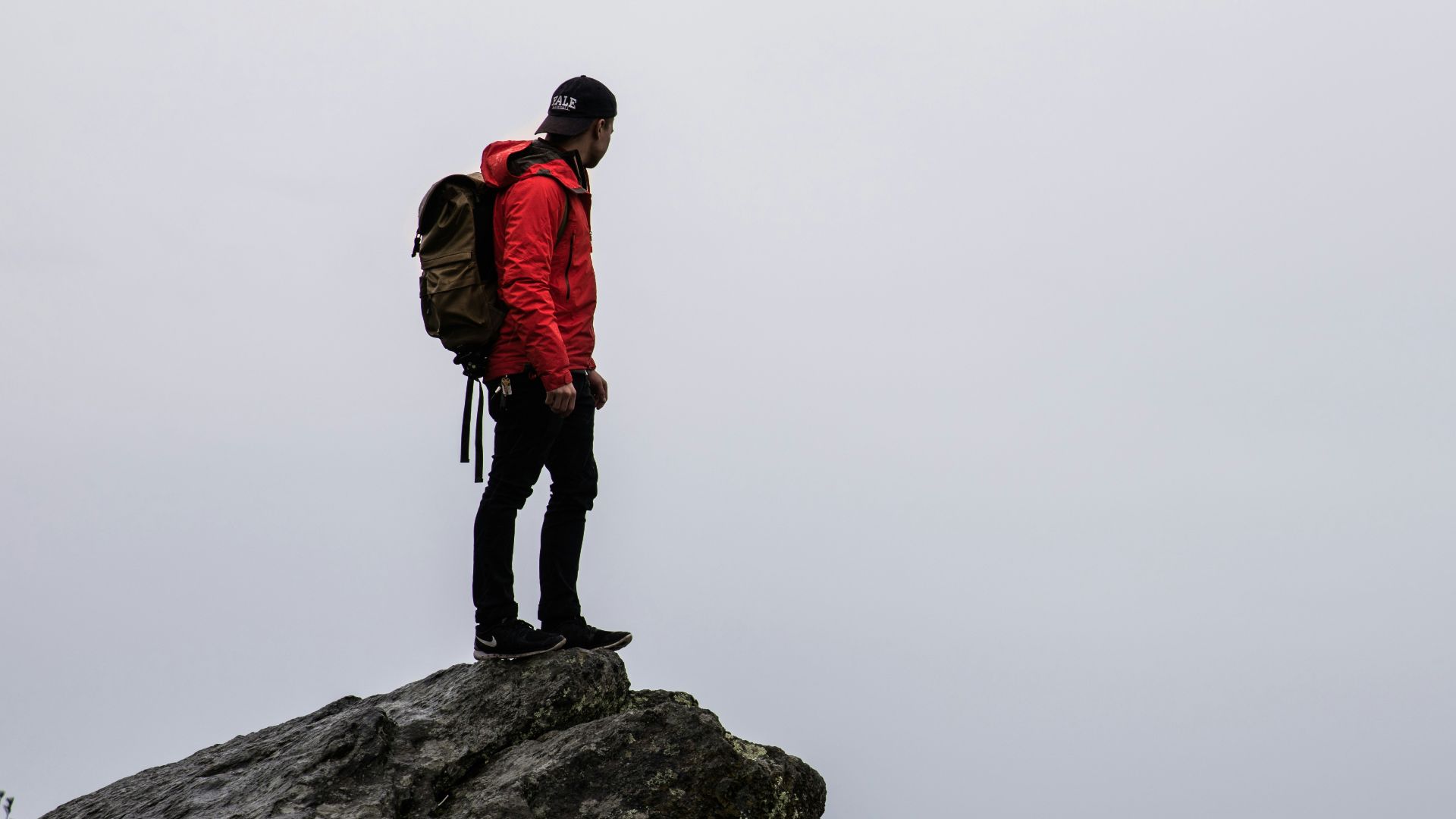person standing on gray rock