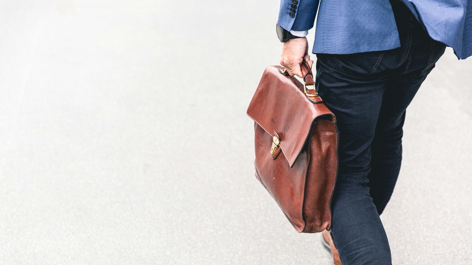 person walking holding brown leather bag