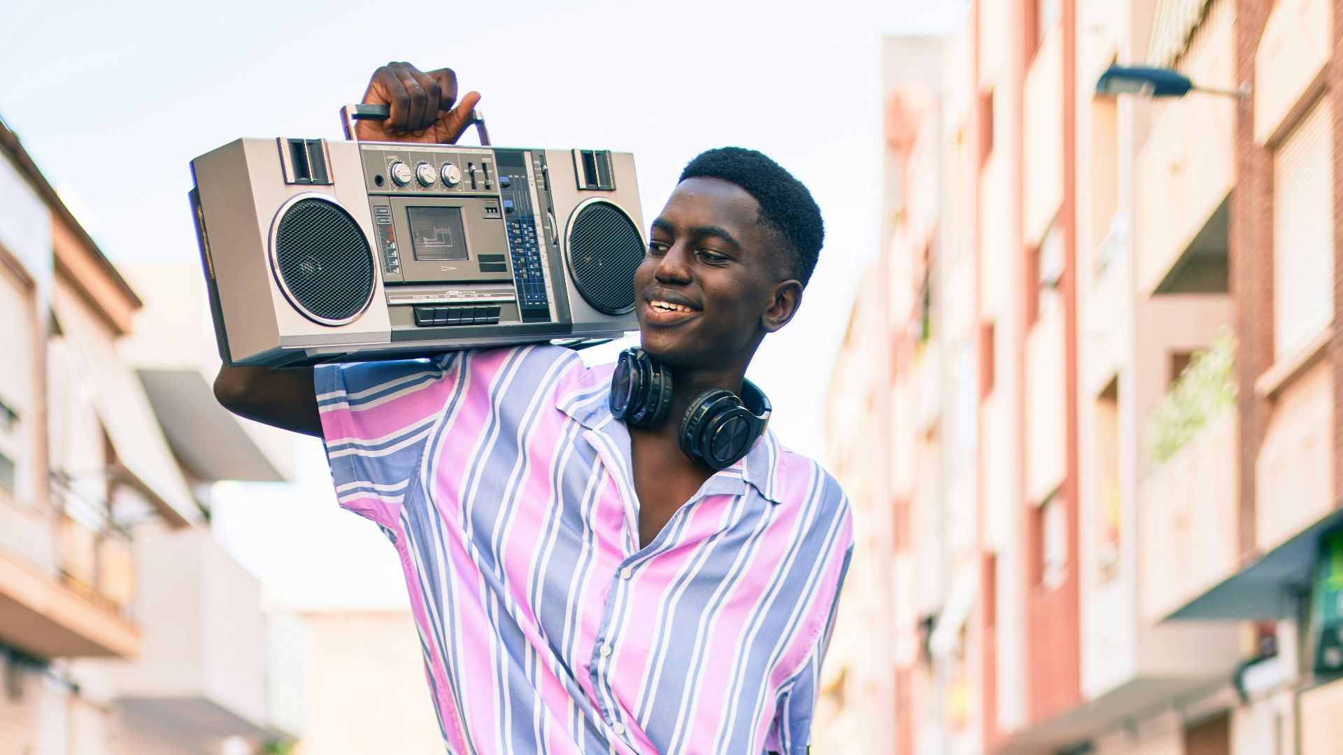 woman in pink and white stripe dress standing on road during daytime
