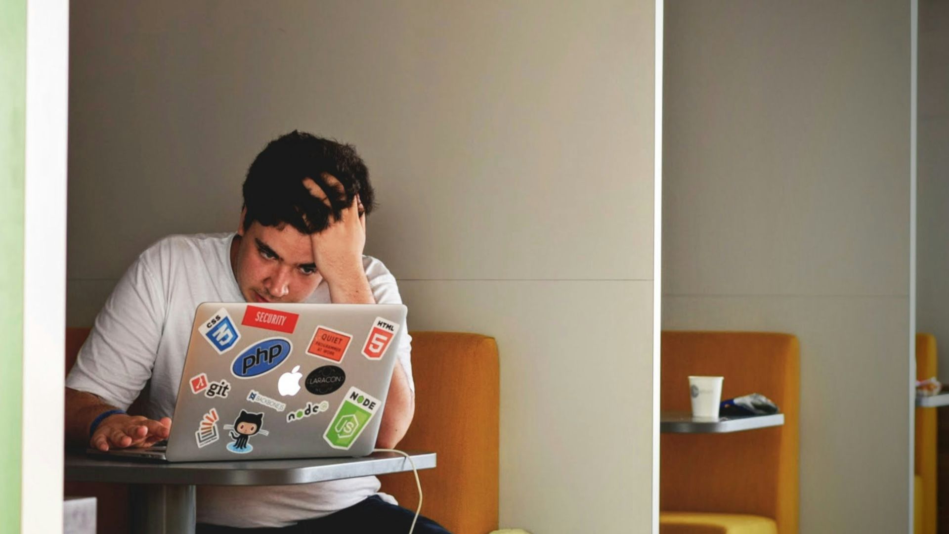 man wearing white top using MacBook