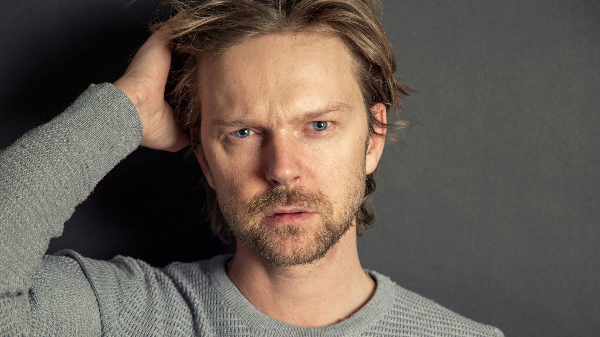 a man with a beard and blue eyes posing for a picture