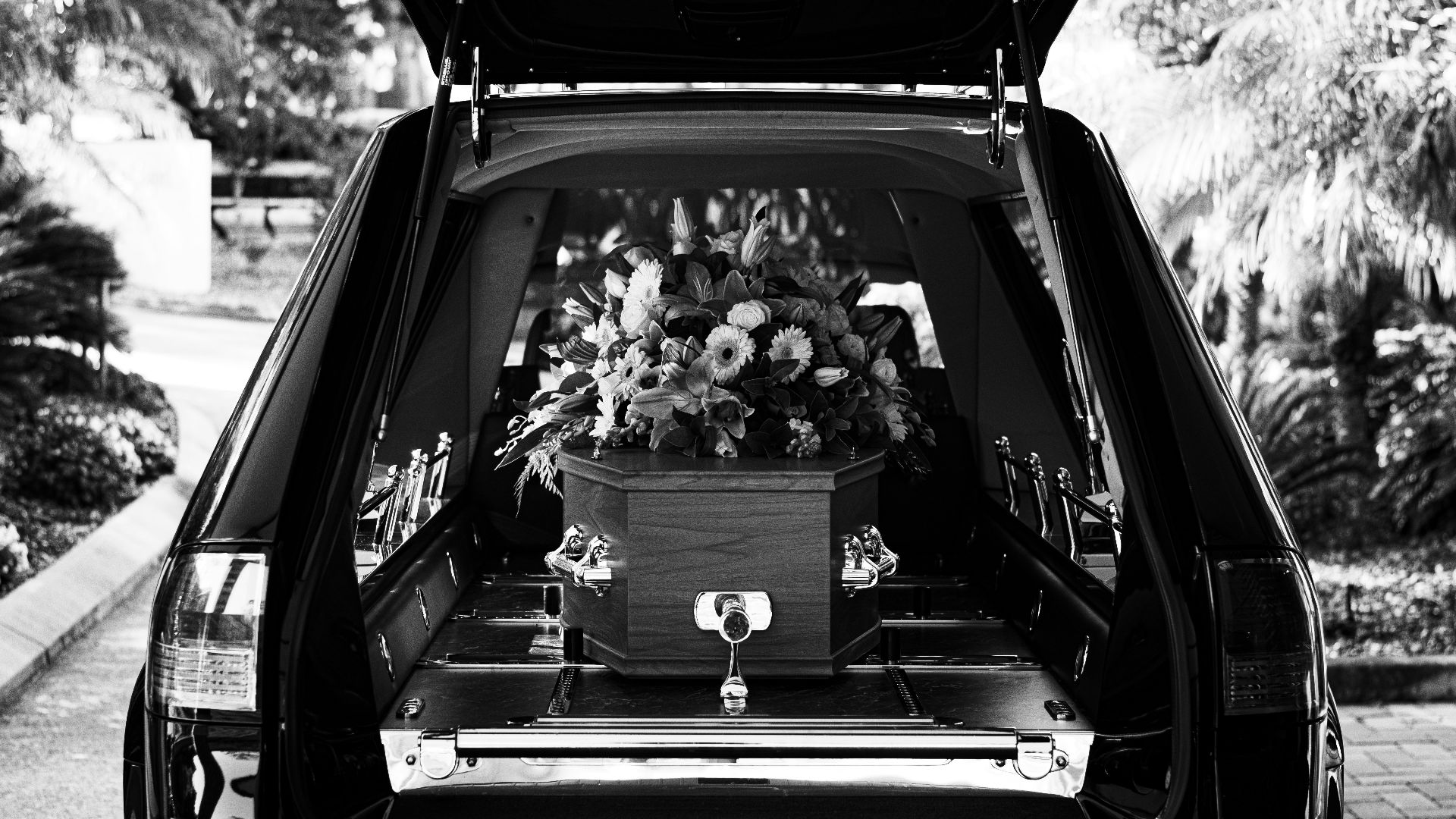 grayscale photo of car with flowers