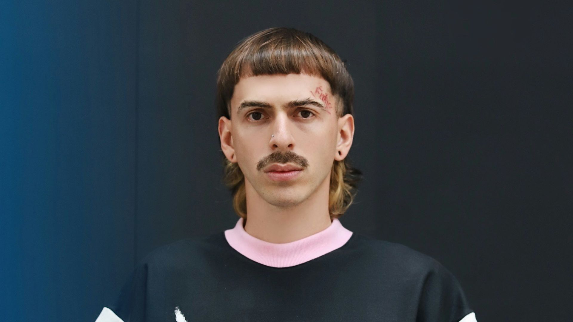 a man standing in front of a blue wall