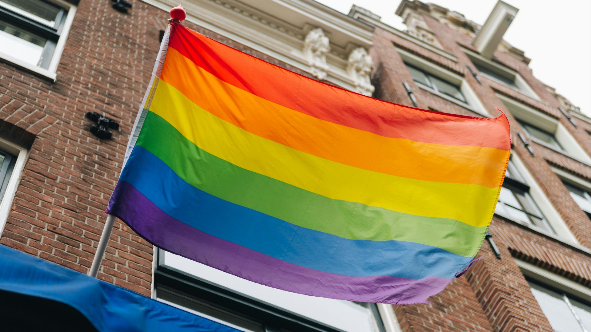 a rainbow flag is flying in front of a building