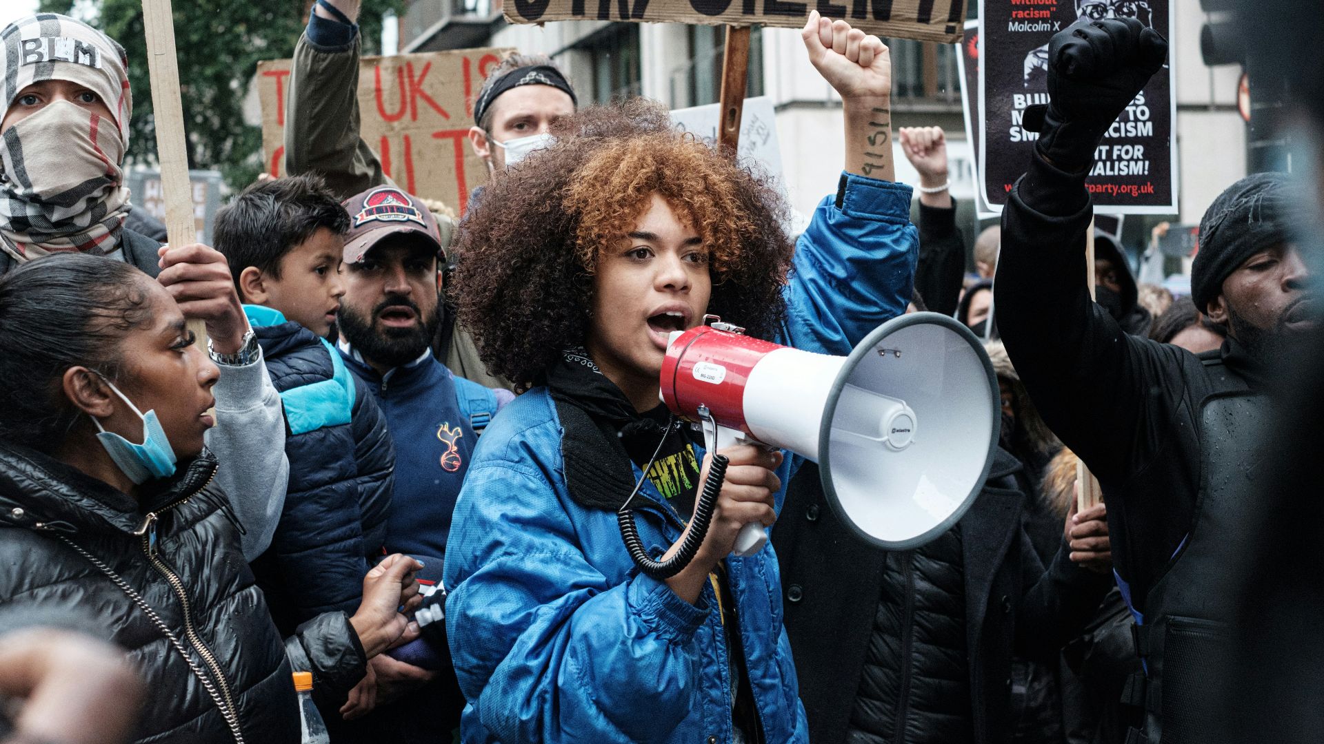 man in blue jacket holding red and white plastic cup