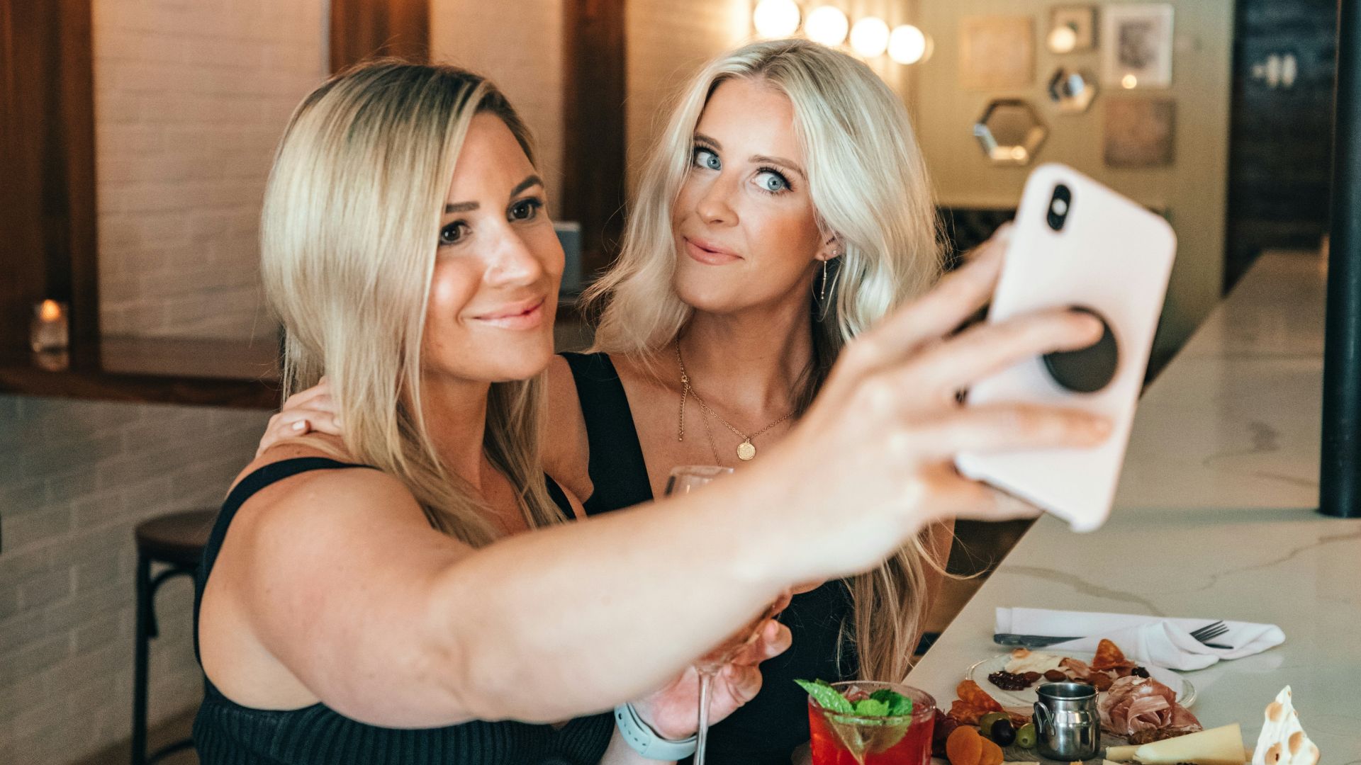 woman in black tank top holding white ceramic mug
