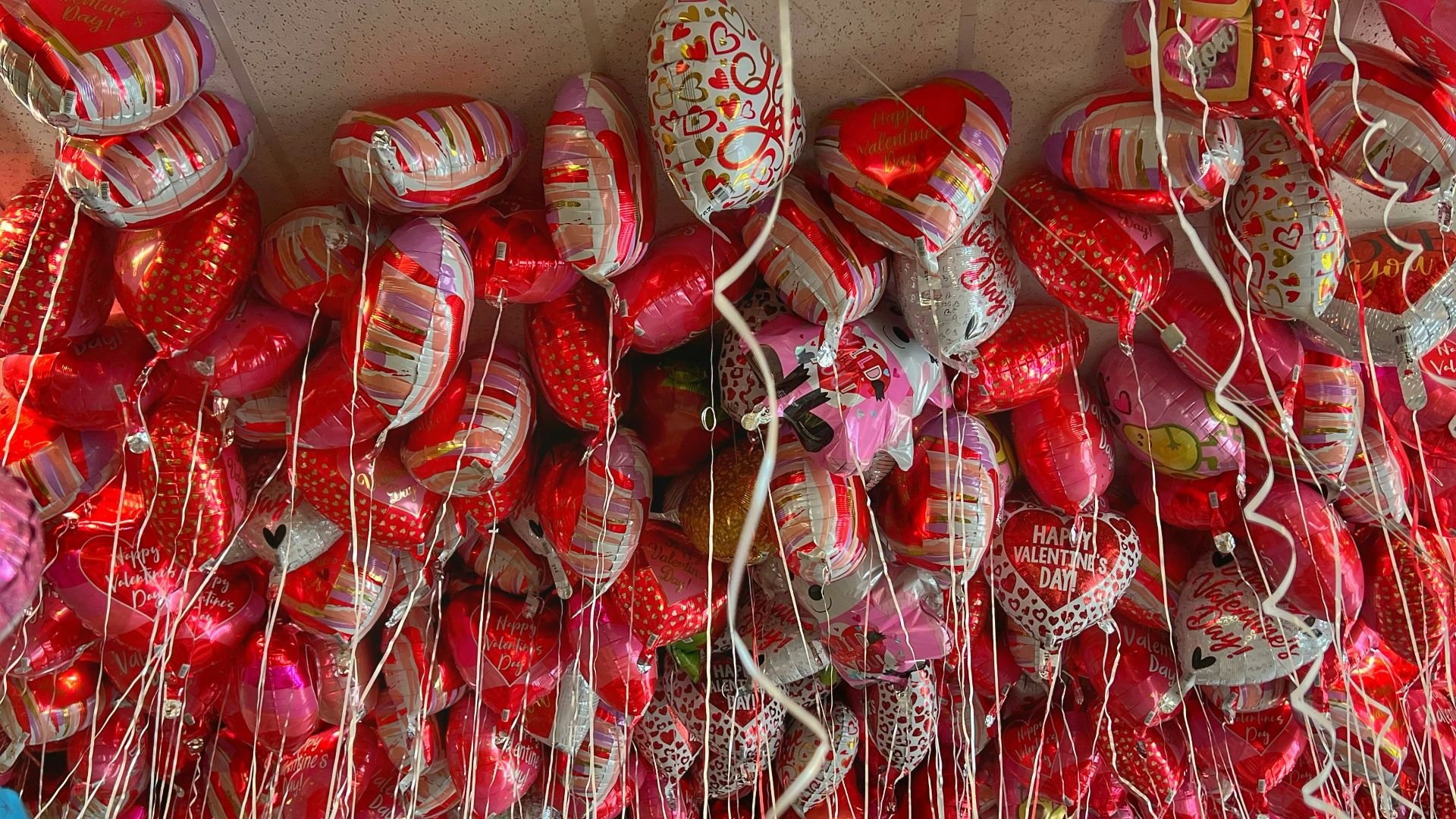 a bunch of red and white shoes hanging on a wall