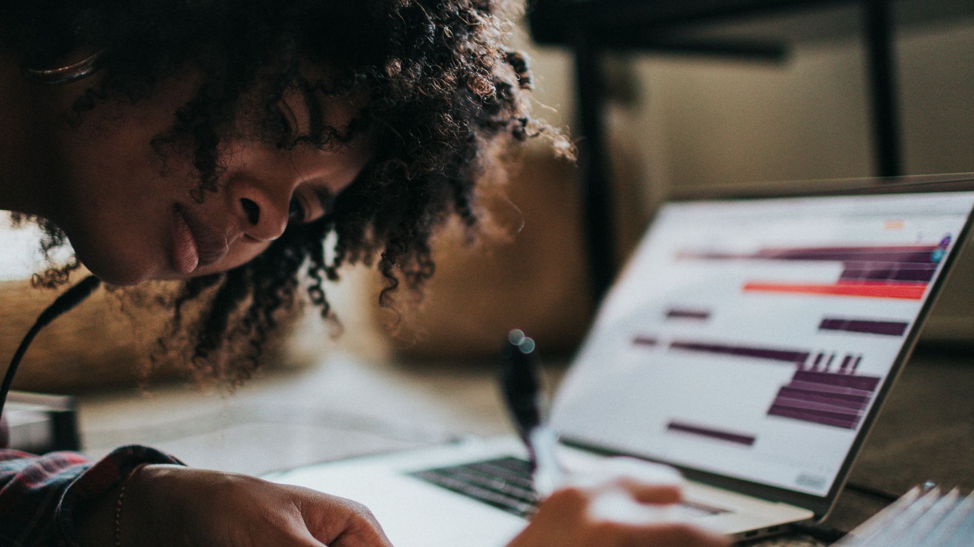 woman in black and white shirt writing on white paper