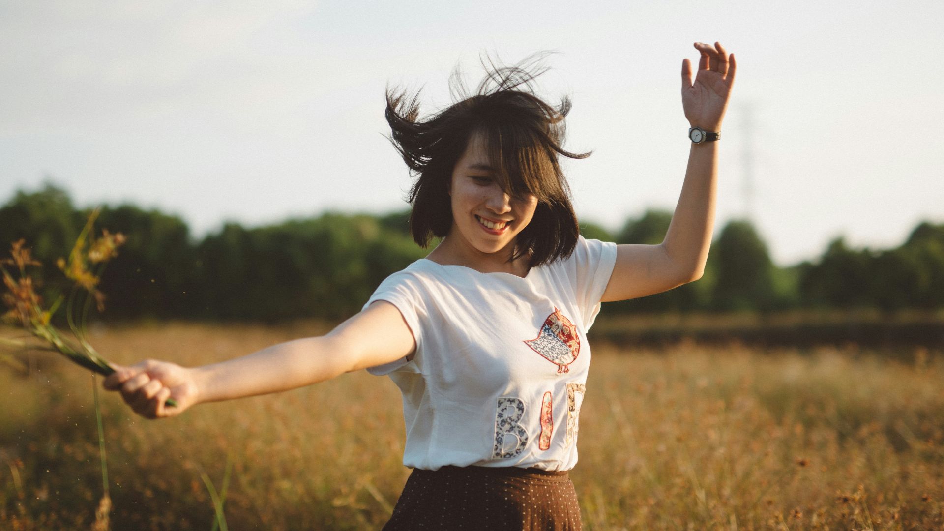 woman holding flower on field