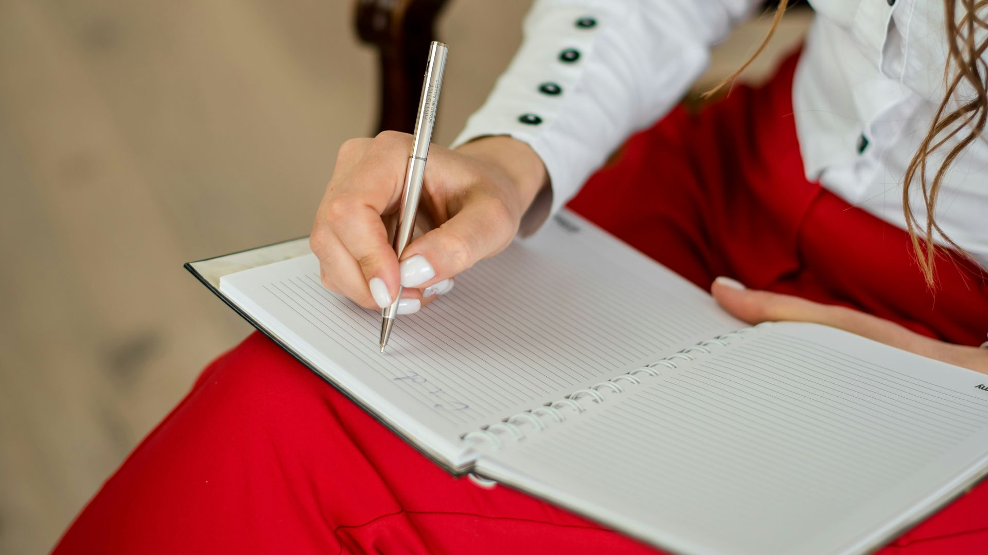 woman in white long sleeve shirt writing on white paper