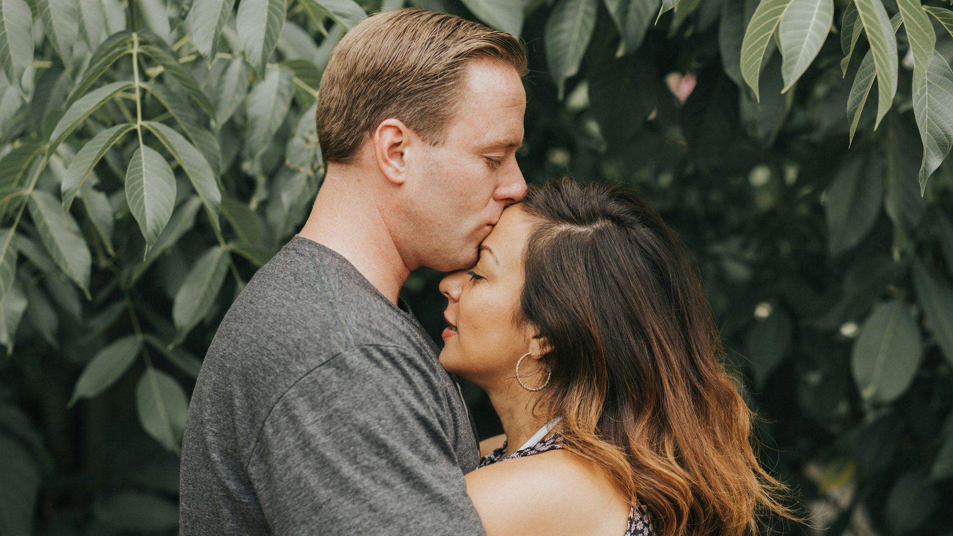 couple hugging near tree leafs