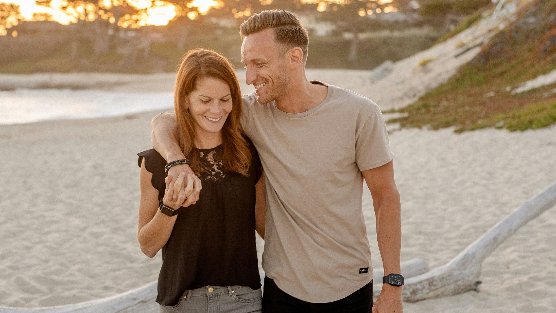 man and woman standing on beach during daytime