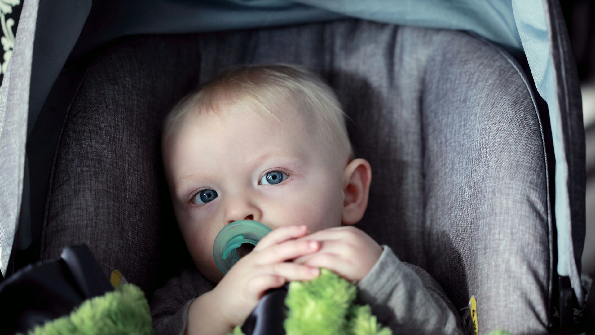 baby on gray stroller