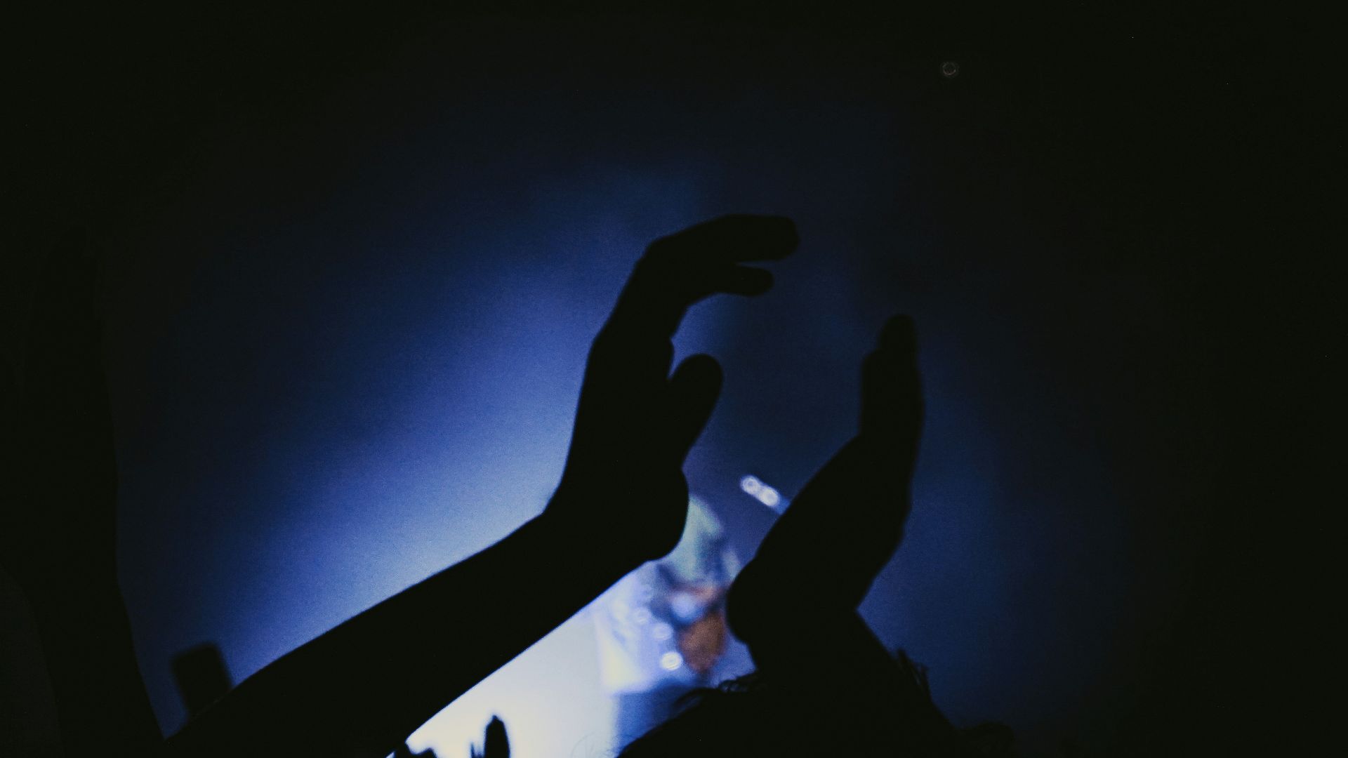 a crowd of people raising their hands in the air