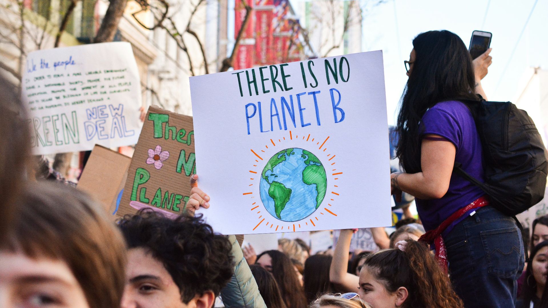 person holding there is no planet b poster