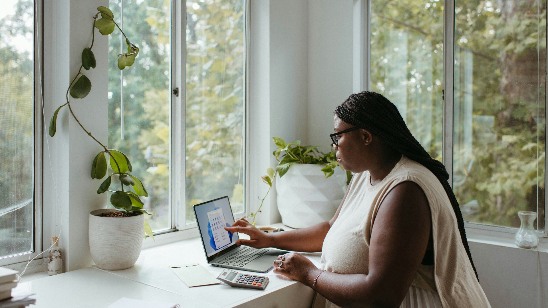 a woman sitting at a table with a laptop