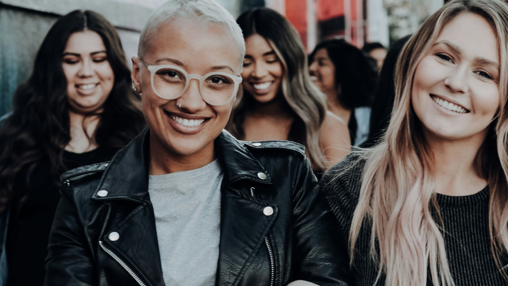 man in black leather jacket beside woman in black and white stripe shirt