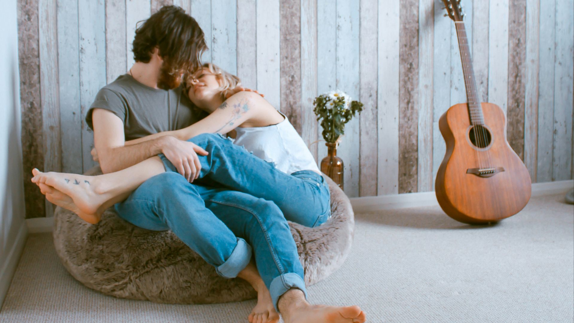 man and woman sitting on gray beanbag
