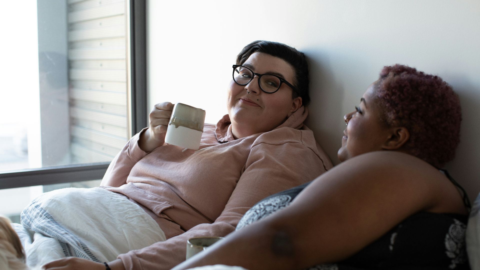 two woman lying on bed
