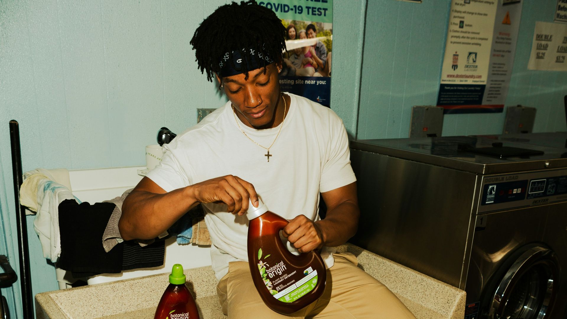 man in white crew neck t-shirt holding brown and black ceramic mug