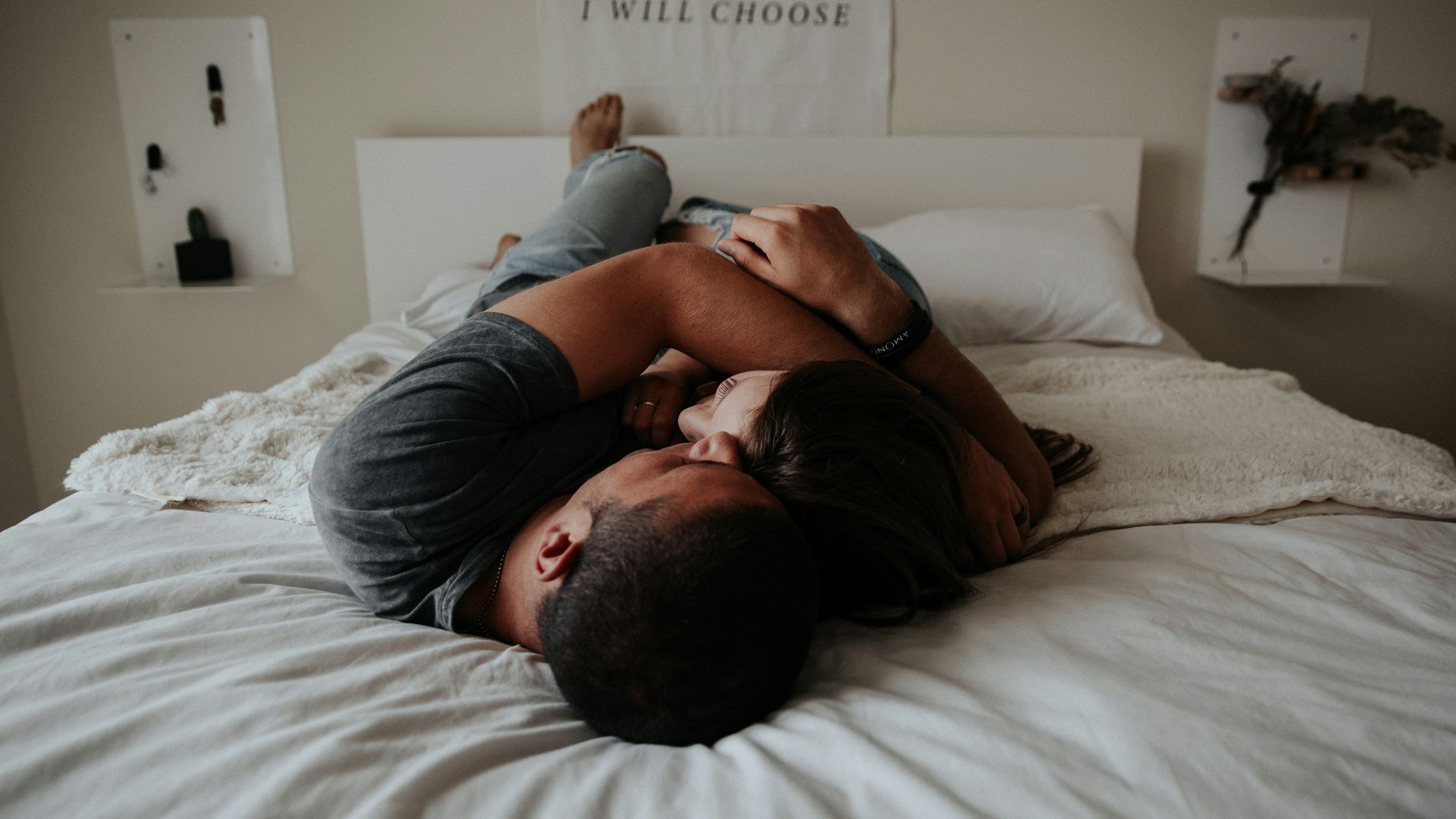 A man and woman cuddling together in bed.