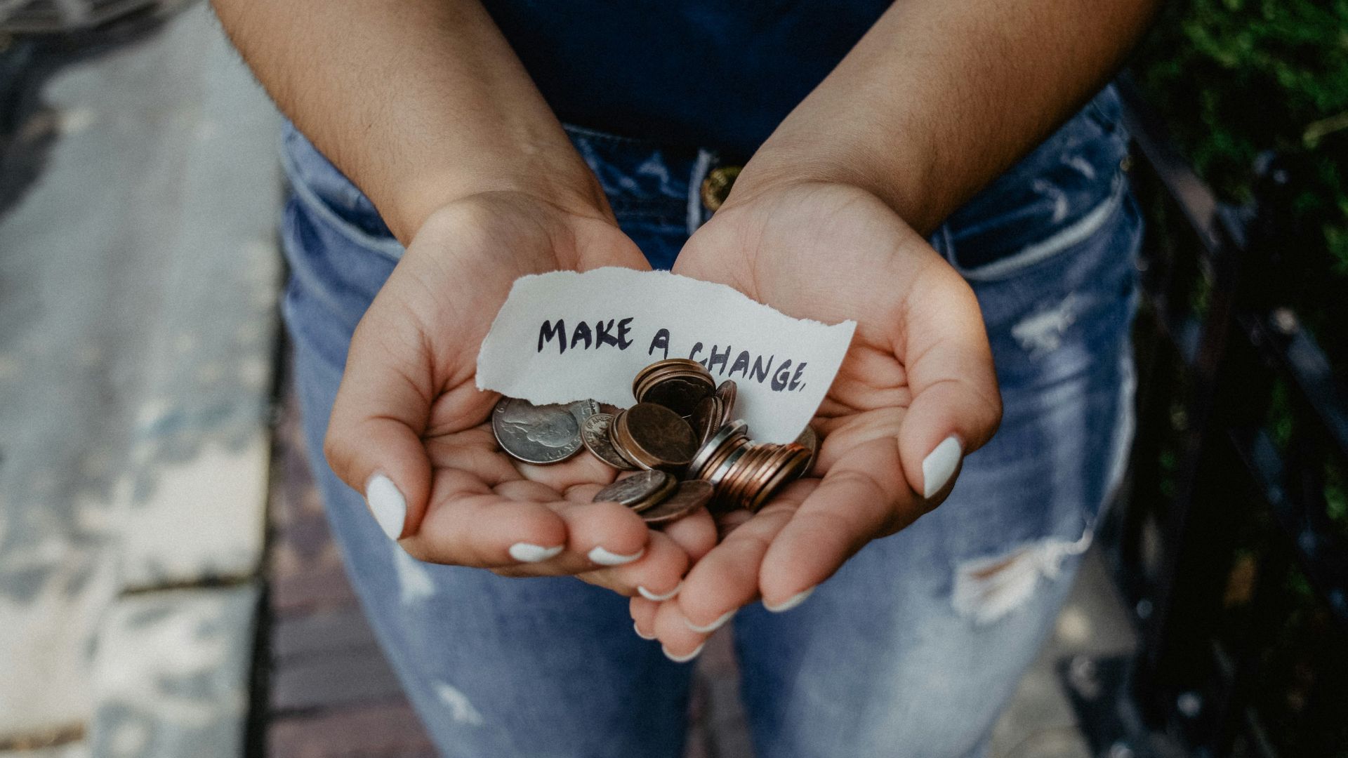 person showing both hands with make a change note and coins
