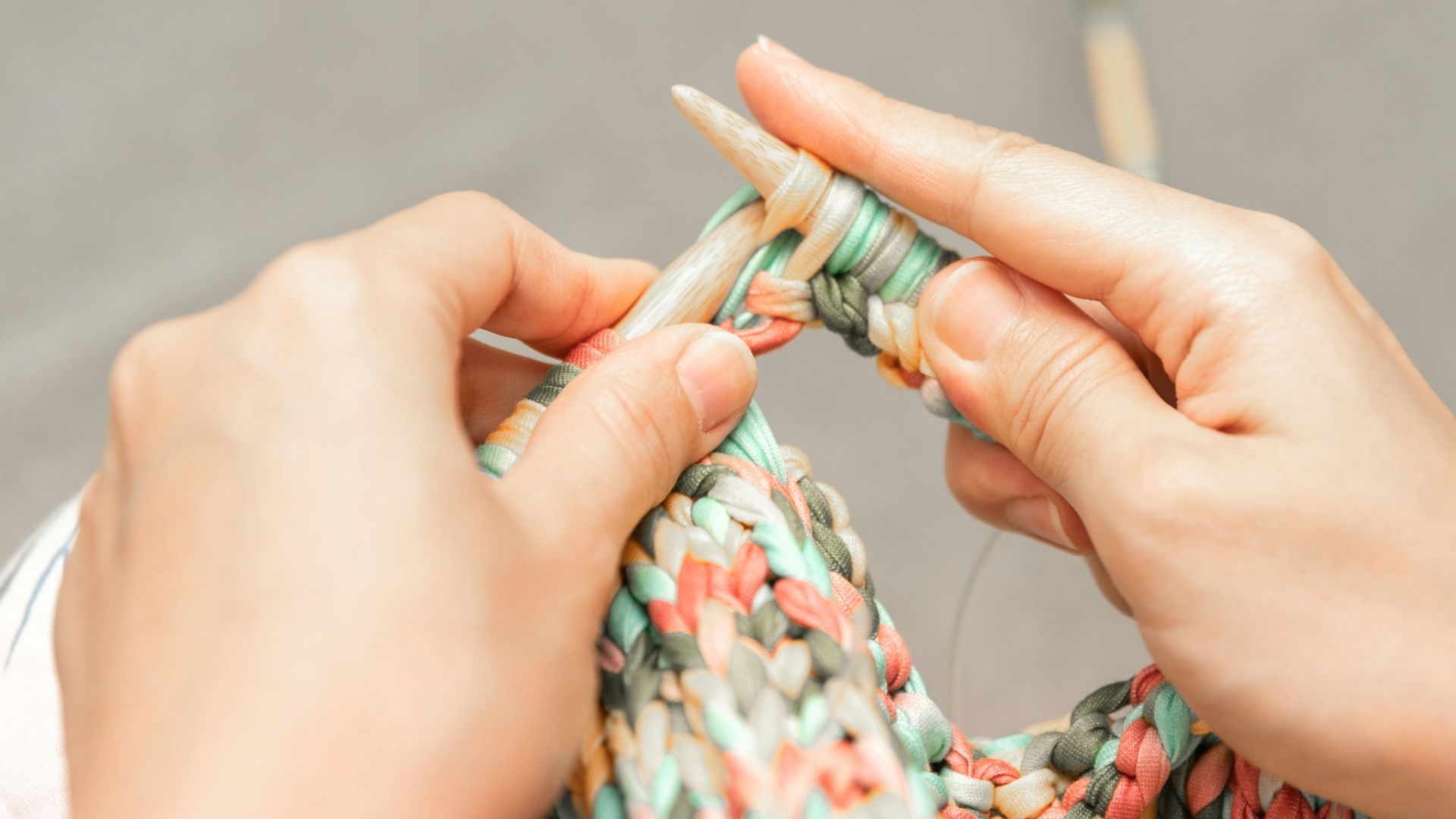 a woman is knitting a piece of fabric