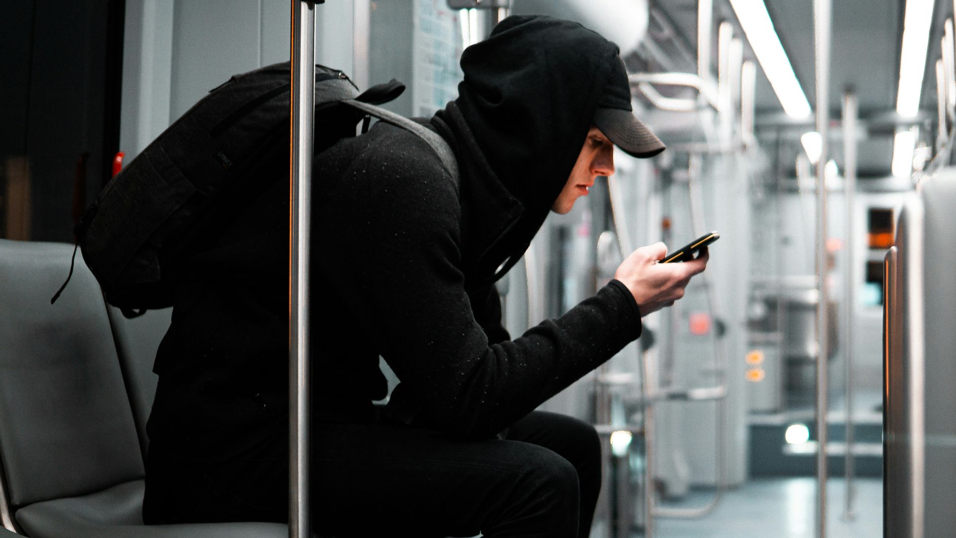 a person sitting on a bus looking at a cell phone
