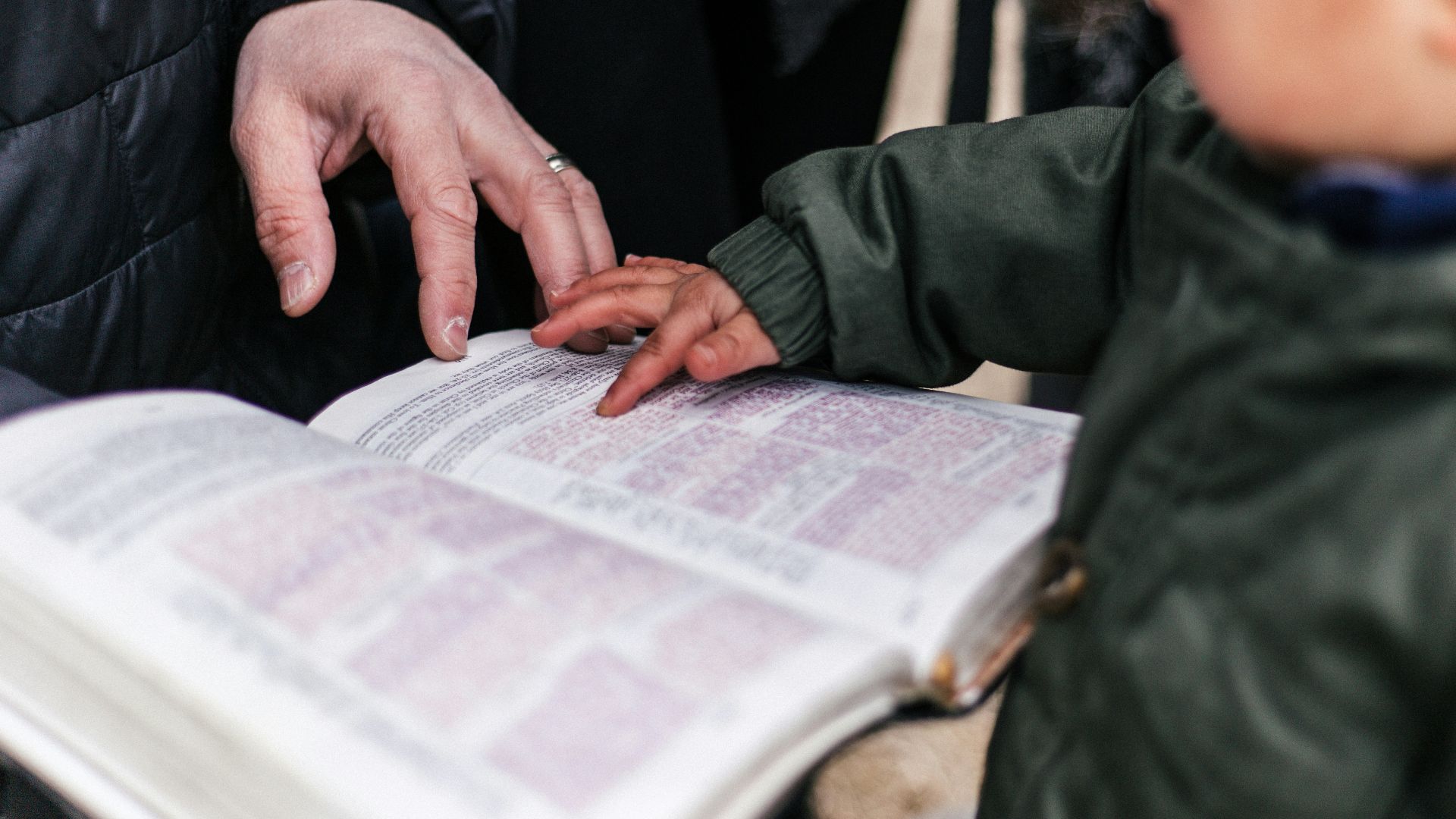 boy touching page of book