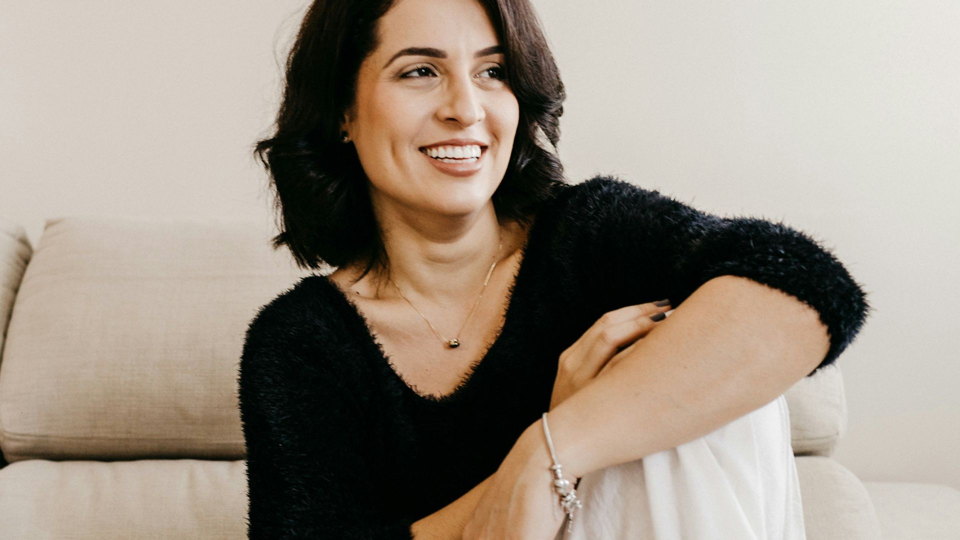 woman in black long sleeve shirt sitting on white couch