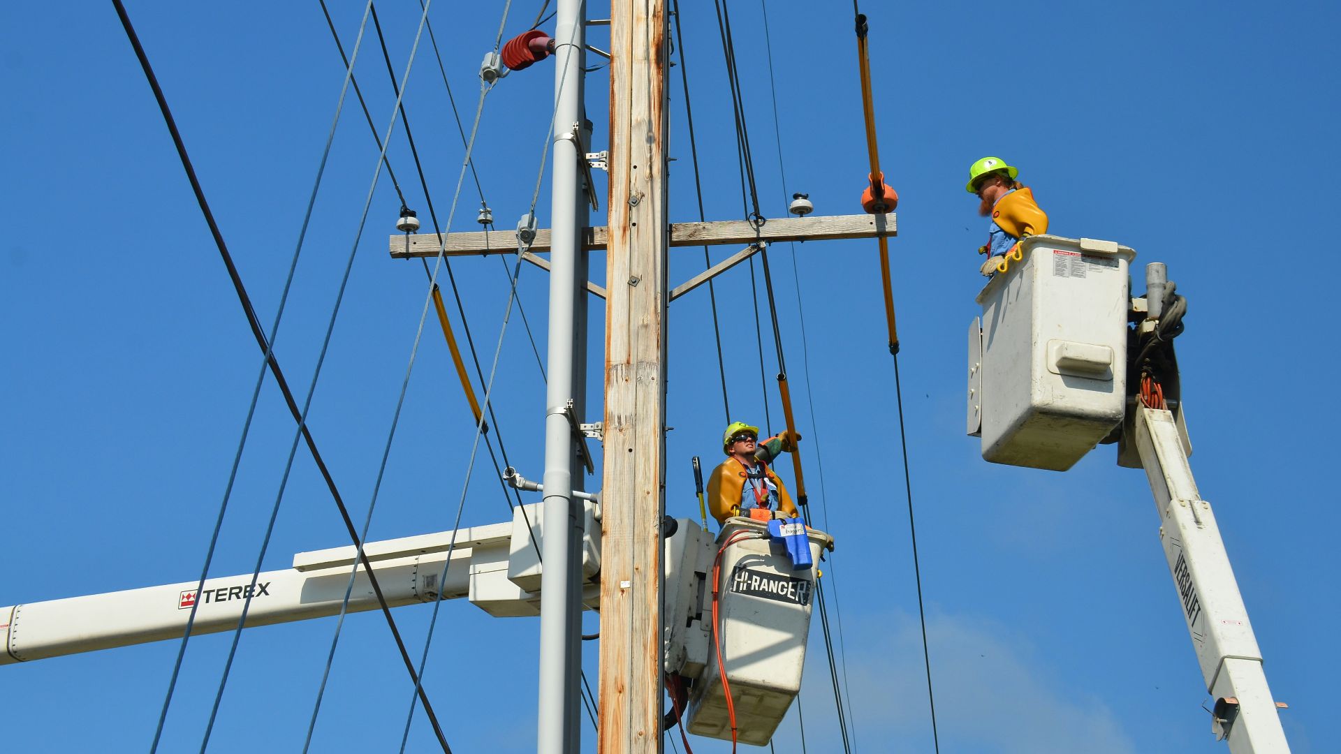 two linemen on cherry pickers