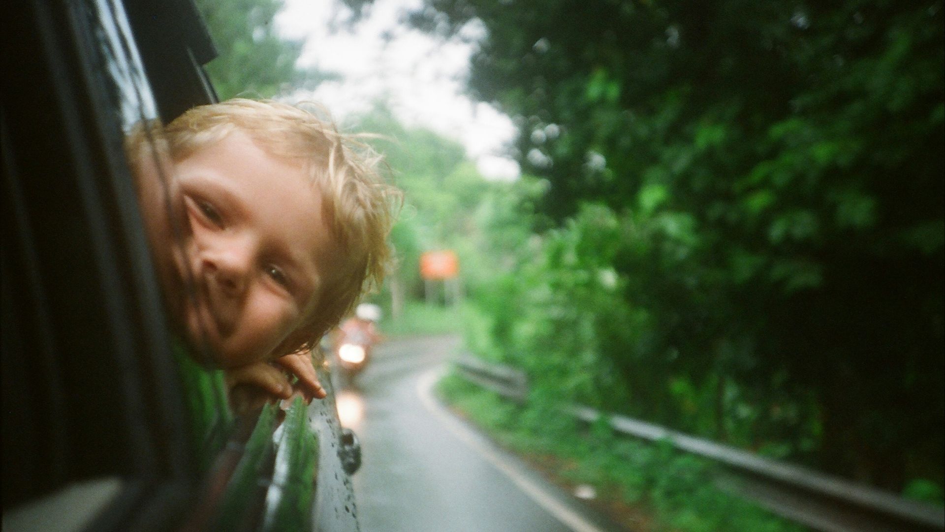 child peeking from vehicle window