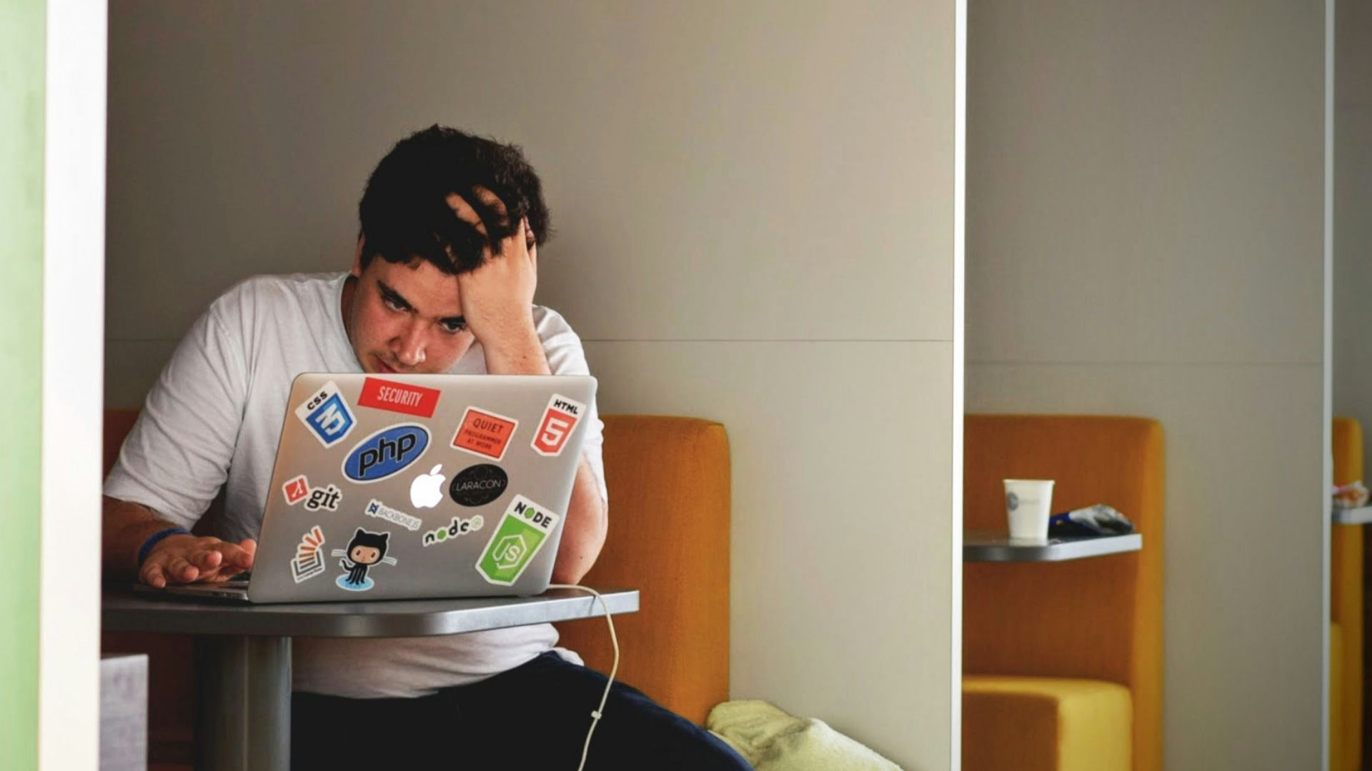 man wearing white top using MacBook