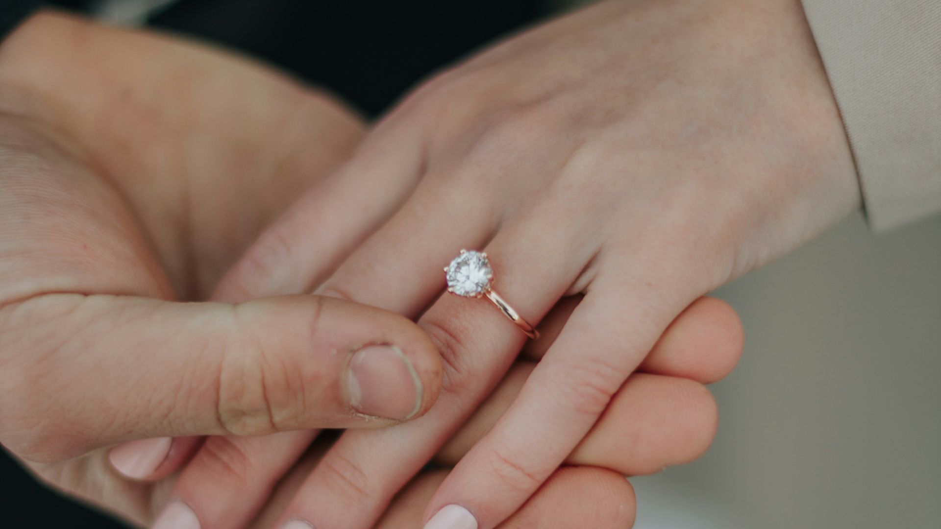 a close up of two people holding hands
