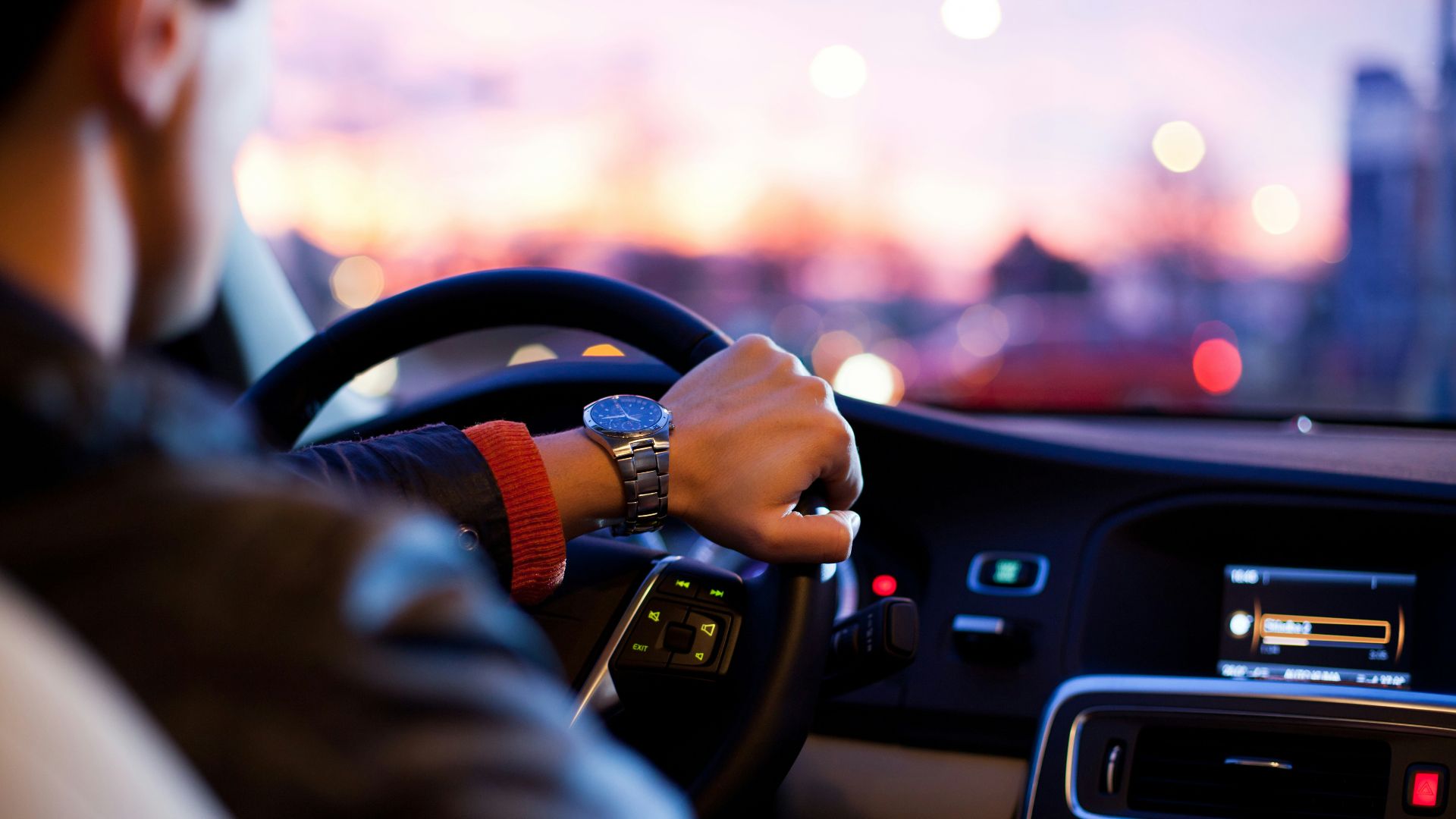 man driving a car wearing wrist watch