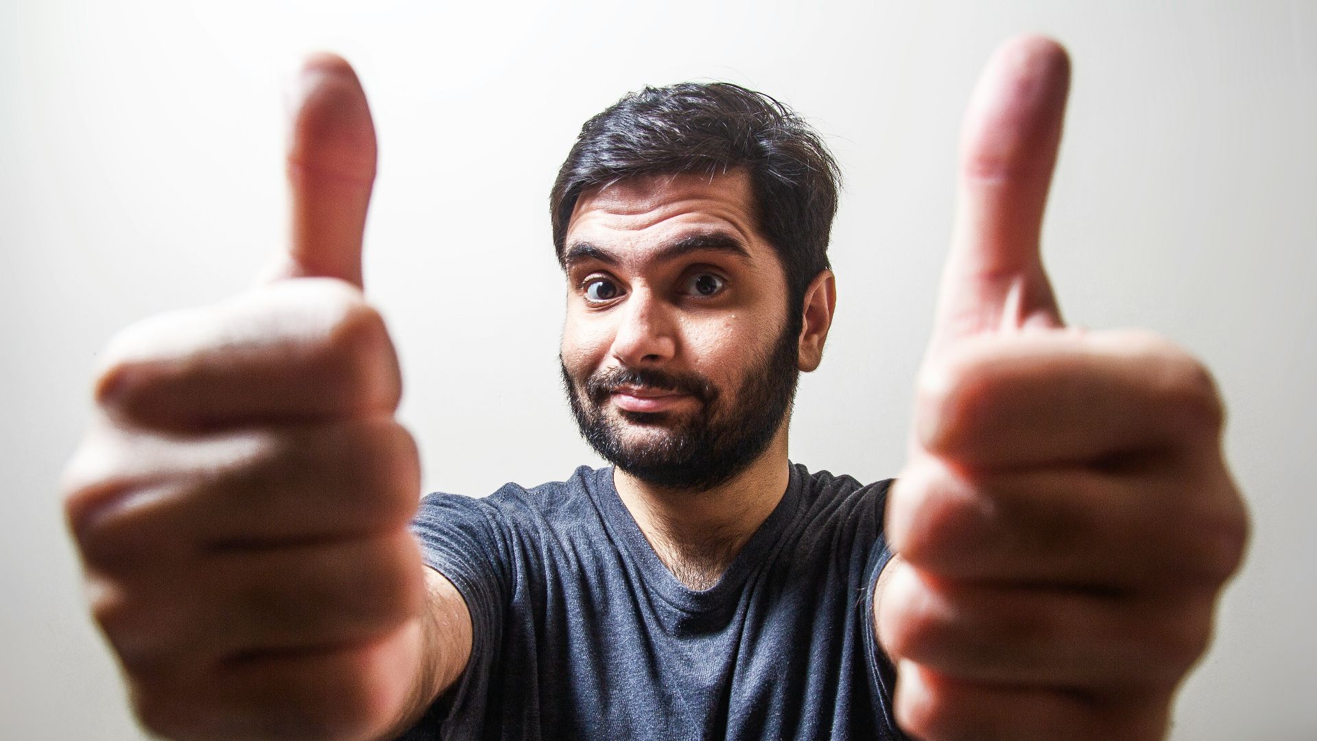 man in gray crew neck shirt making thumbs up