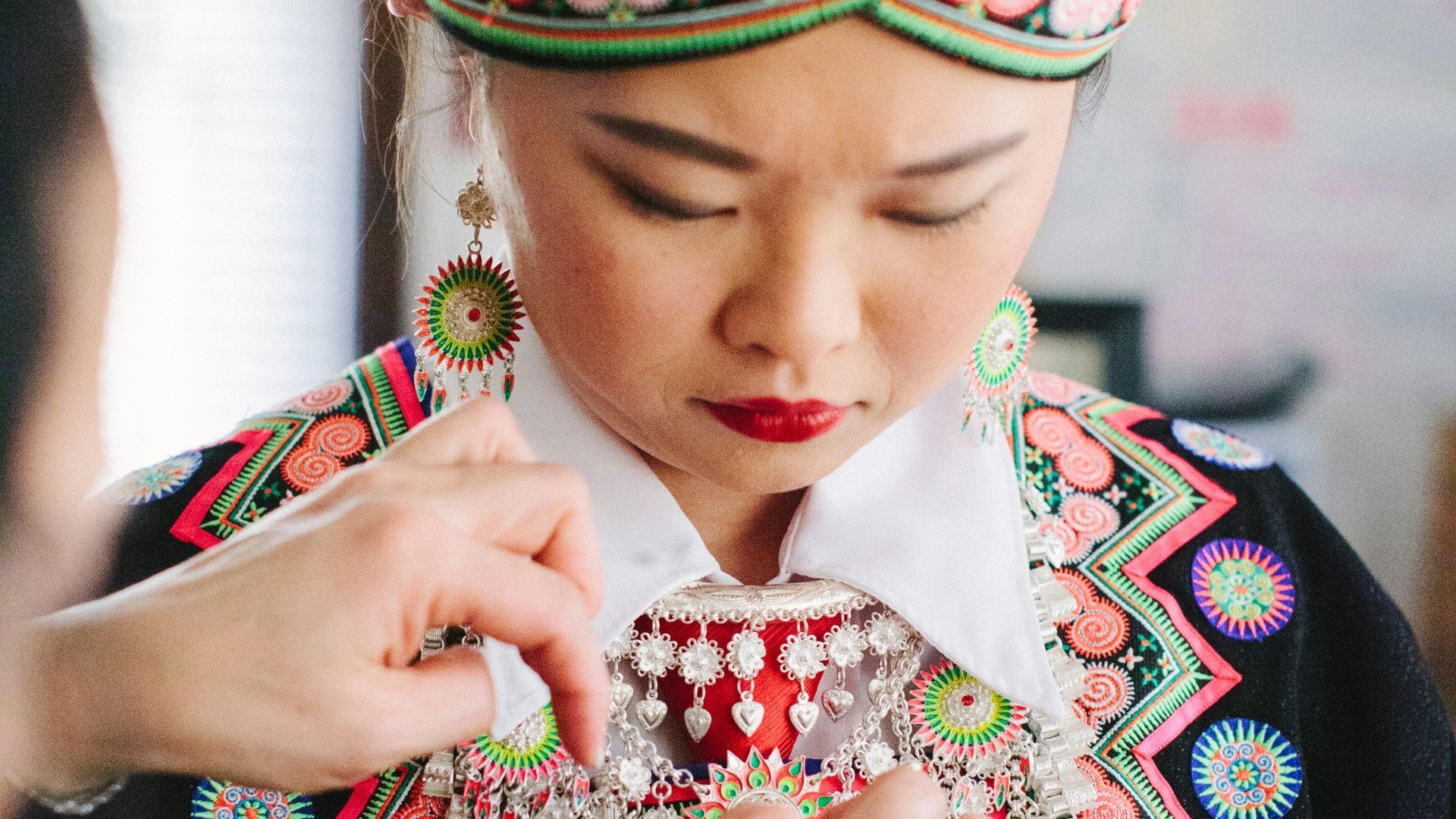 woman in black and red floral dress wearing green and yellow headdress