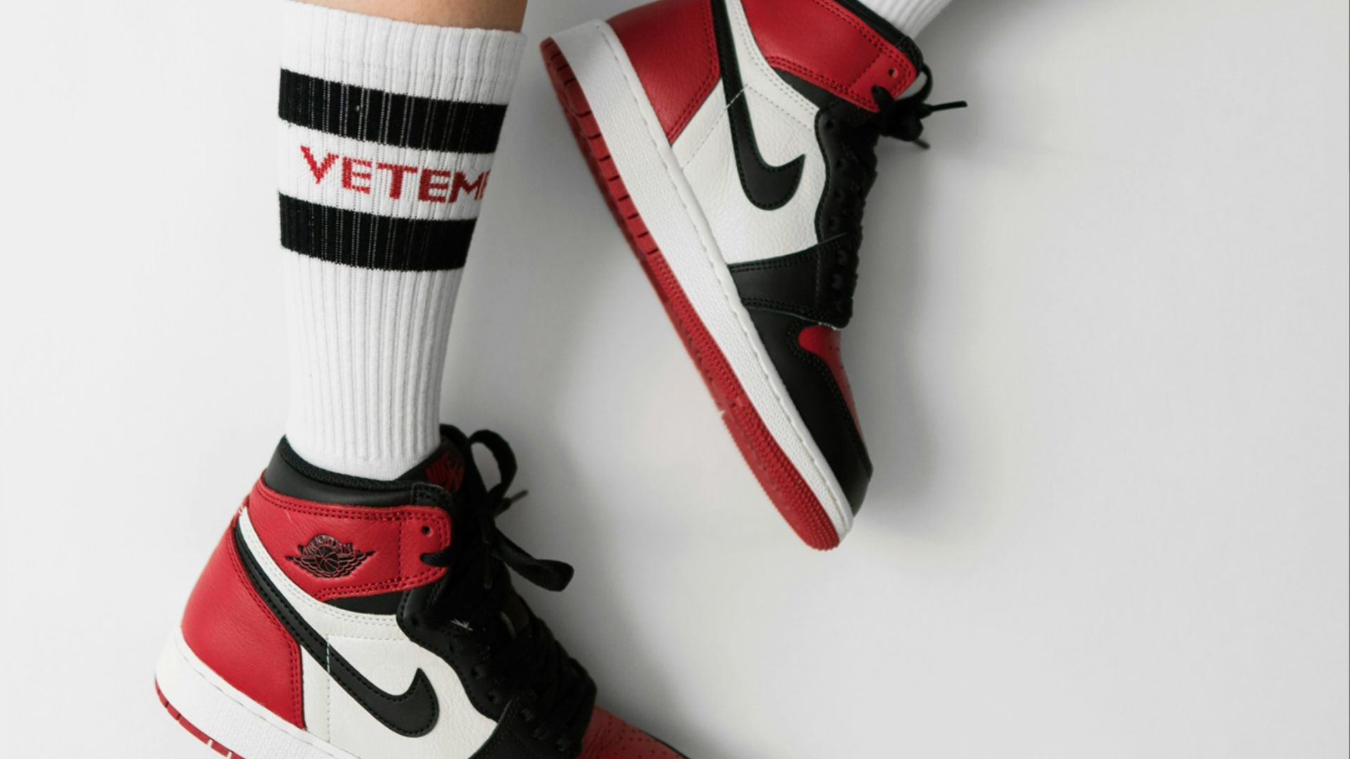 person wearing pair of black toe Air Jordan 1's