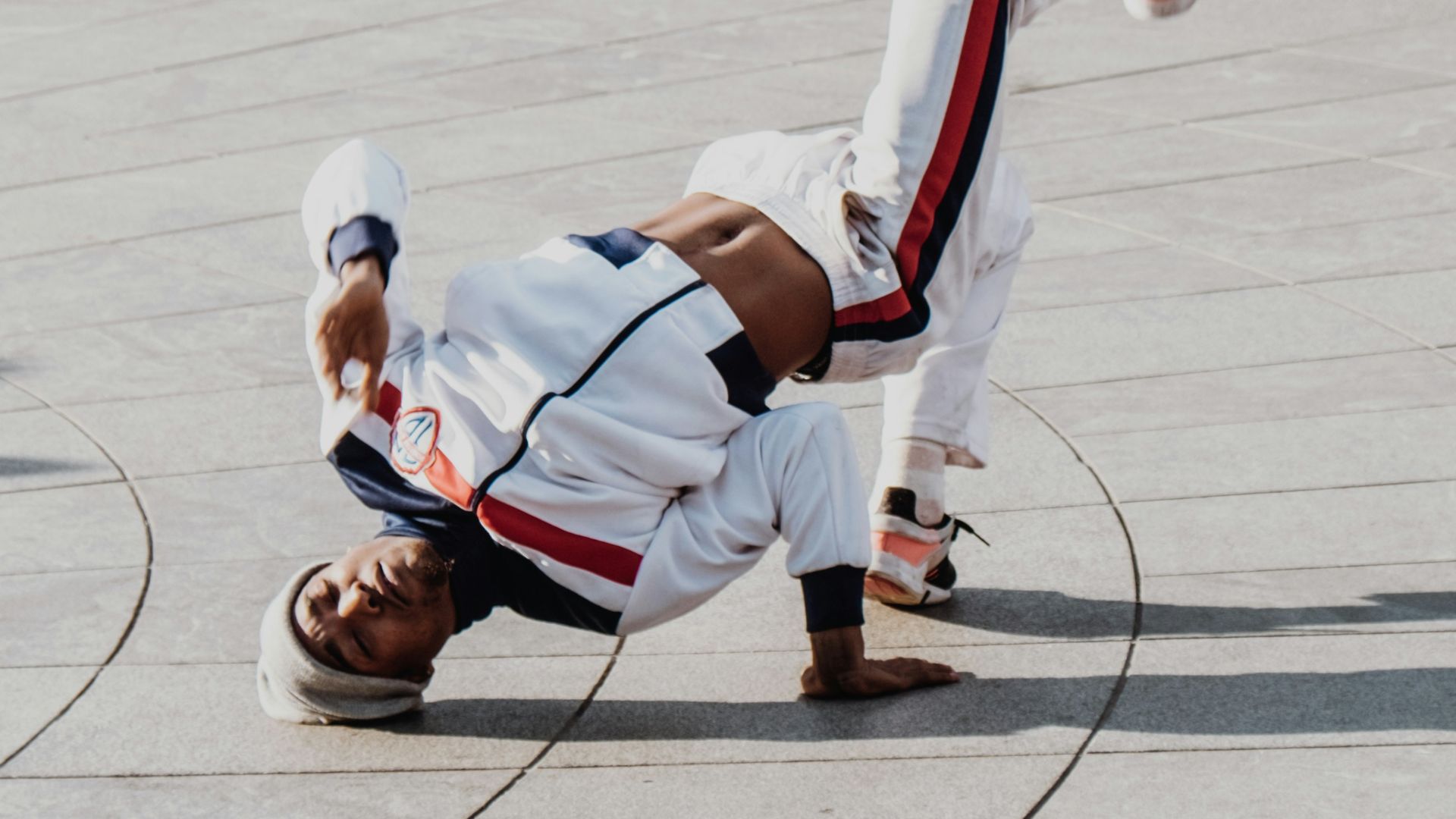 man doing bboy in front of people at daytime