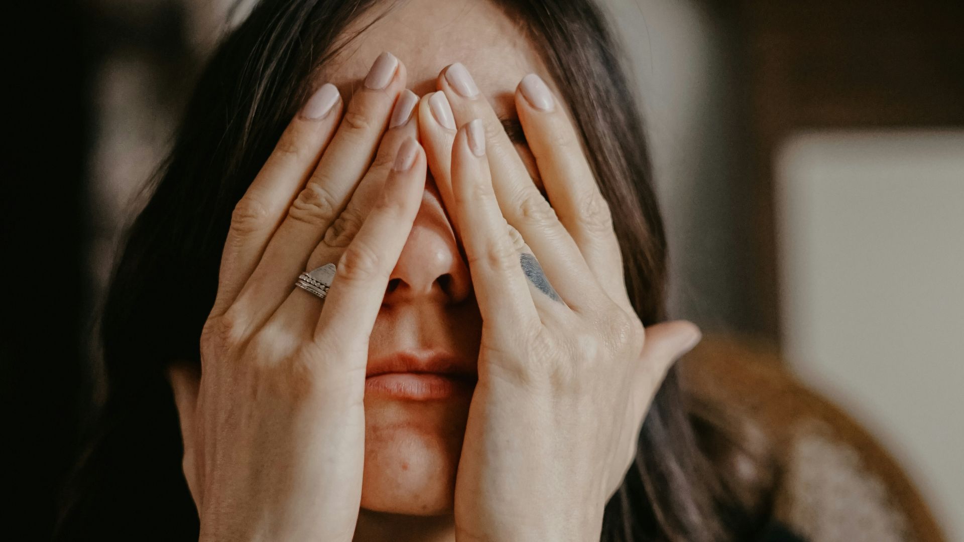 woman in black long sleeve shirt covering her face