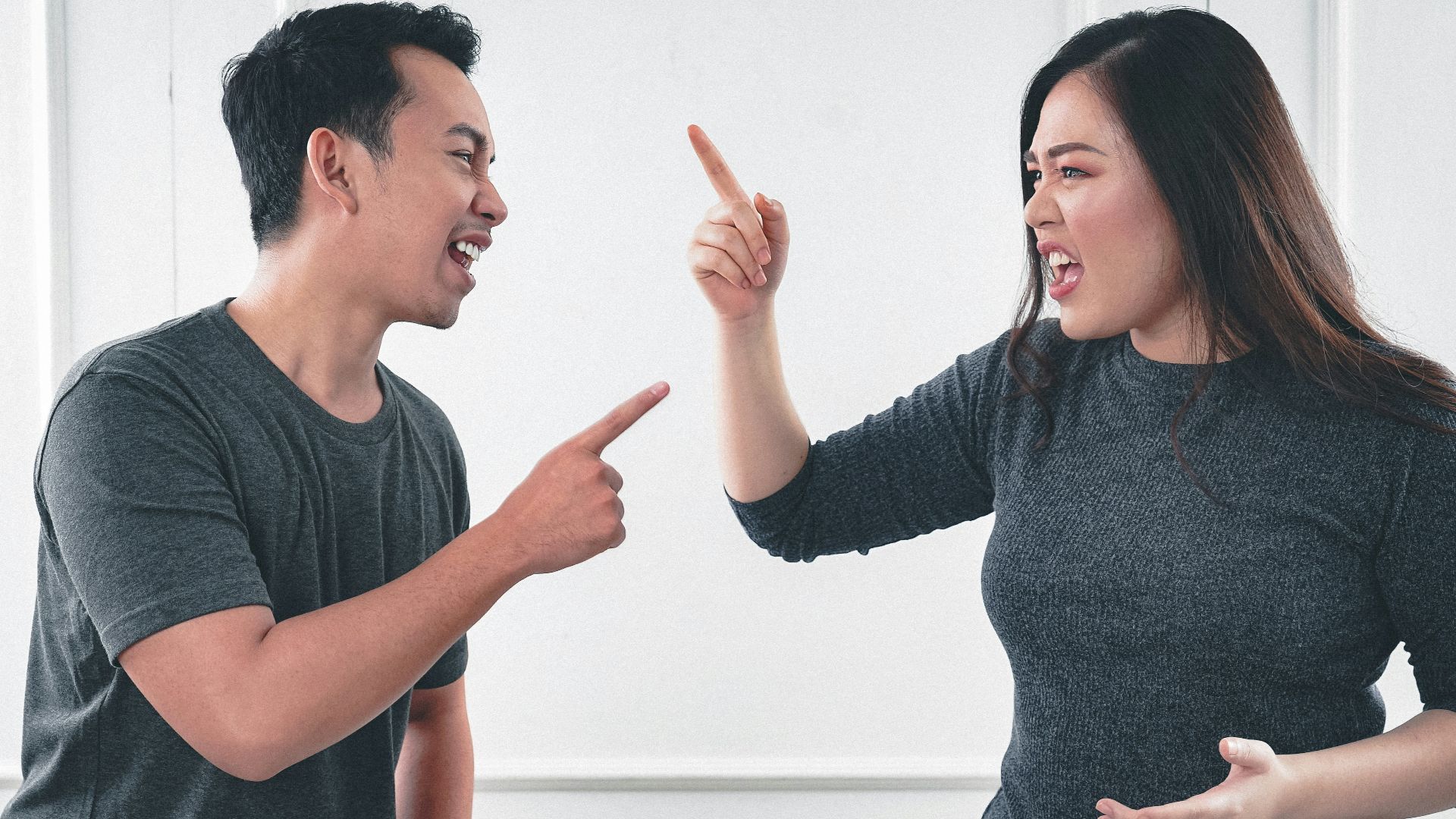 man in gray crew neck long sleeve shirt standing beside woman in black crew neck shirt