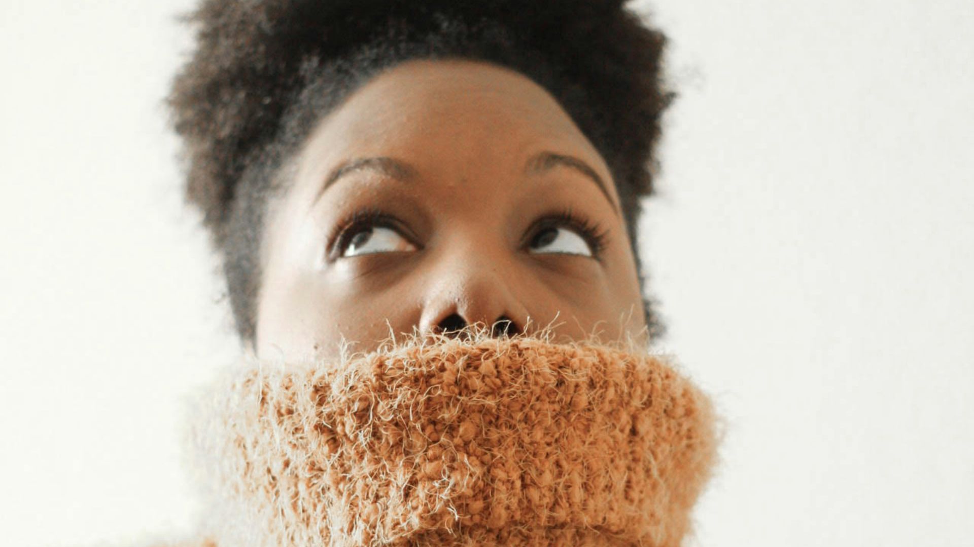 woman wearing orange turtle neck sweat shirt looking upward
