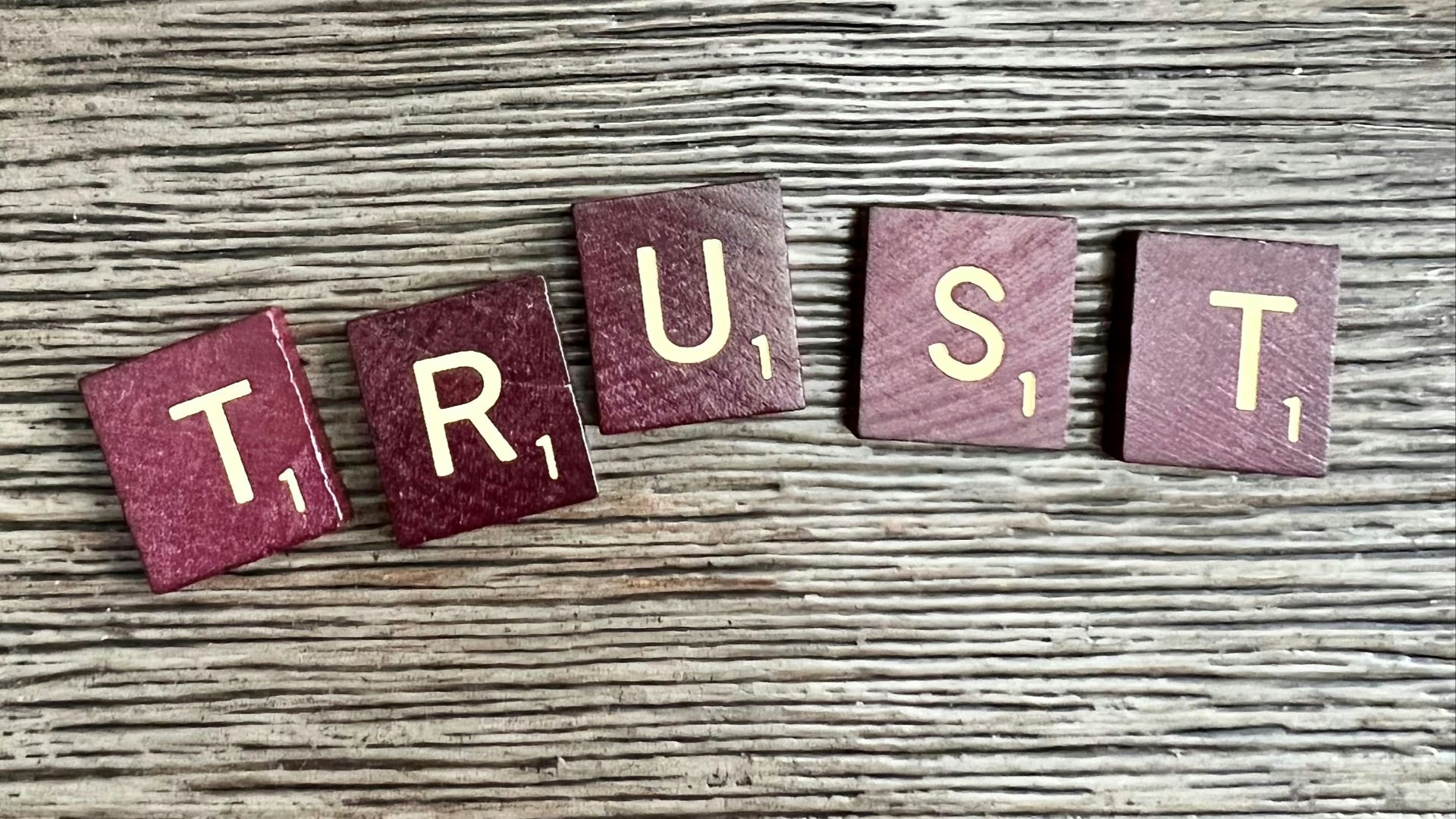 trust spelled with wooden letter blocks on a table