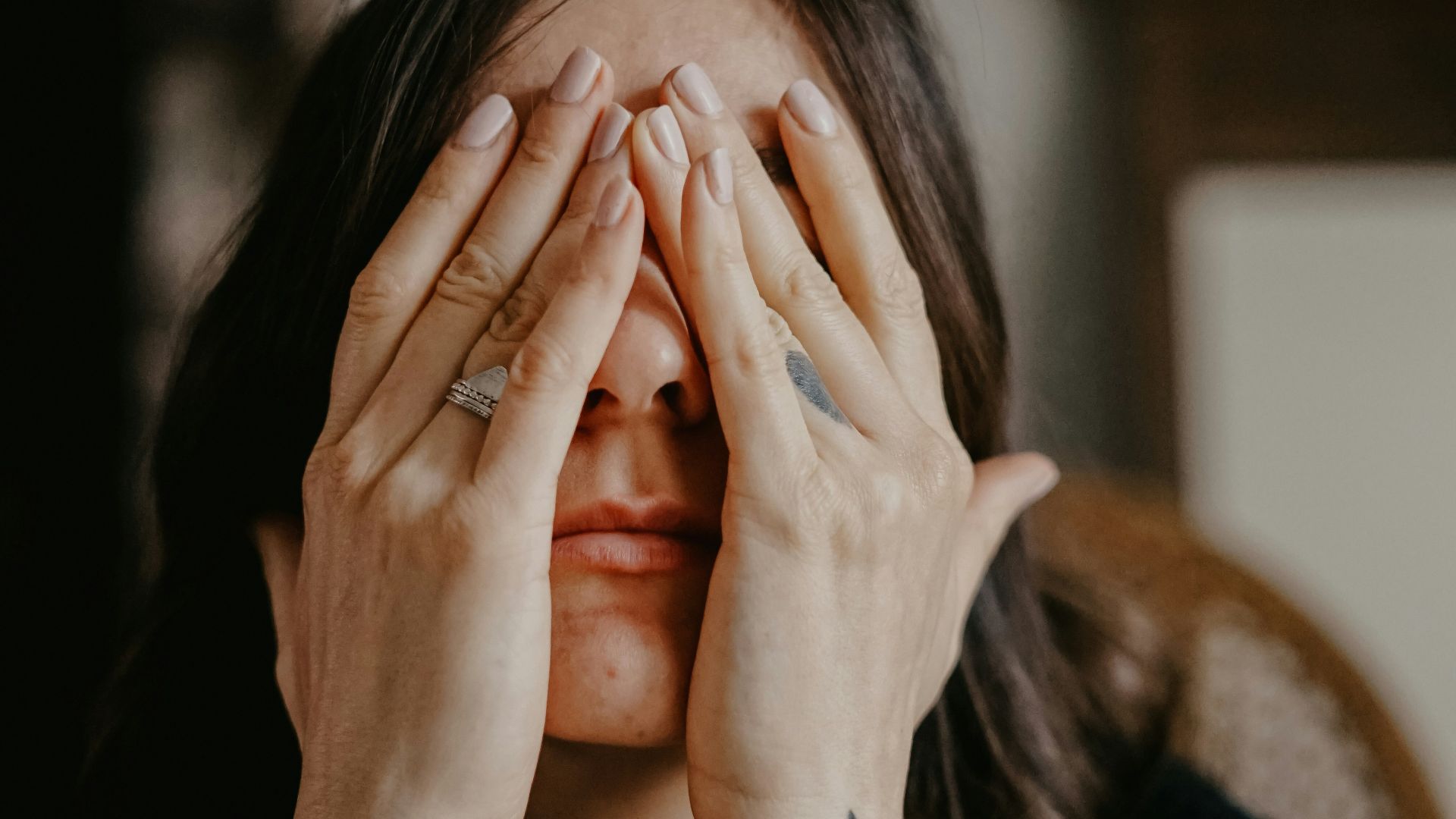 woman in black long sleeve shirt covering her face