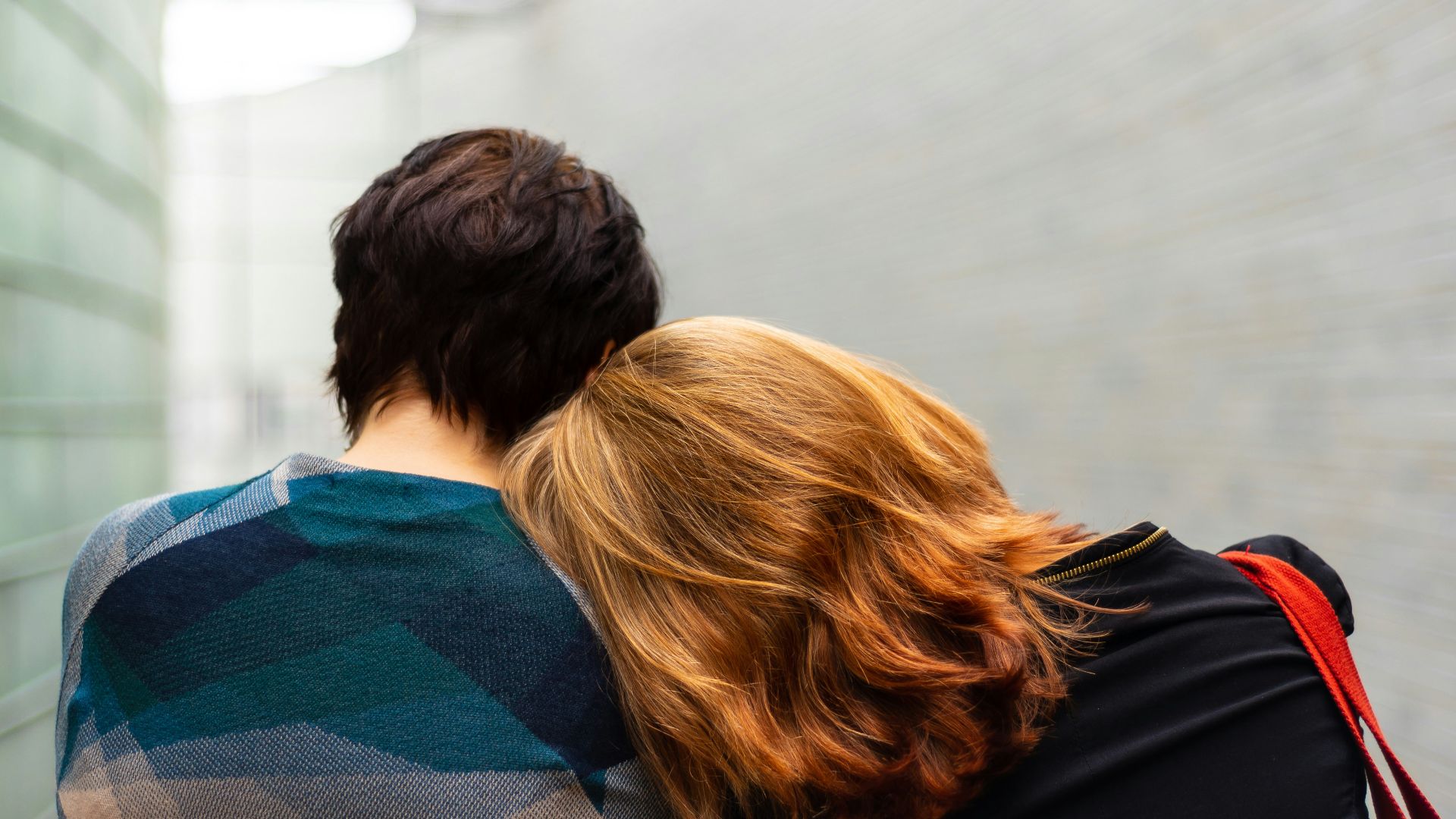 a woman rests her head on another person's shoulder