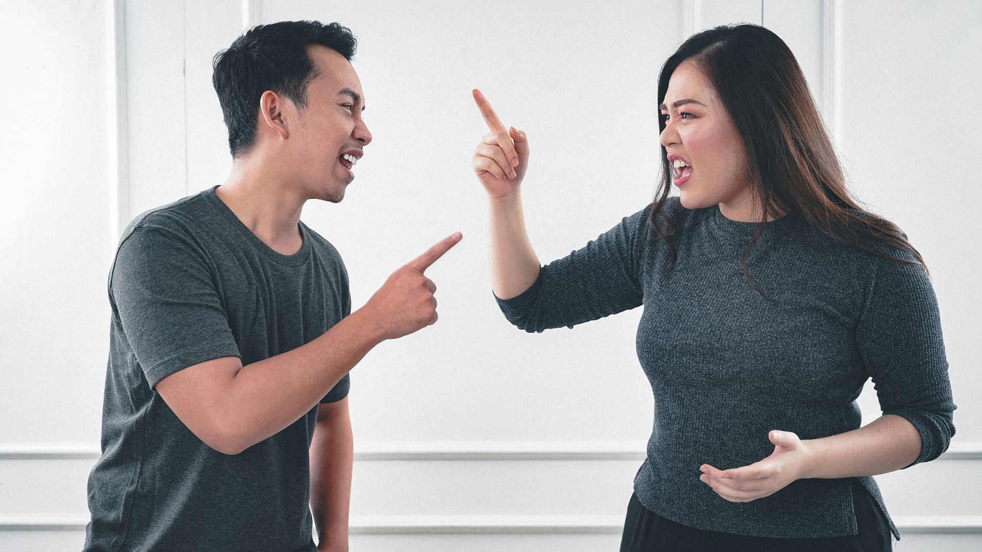 man in gray crew neck long sleeve shirt standing beside woman in black crew neck shirt