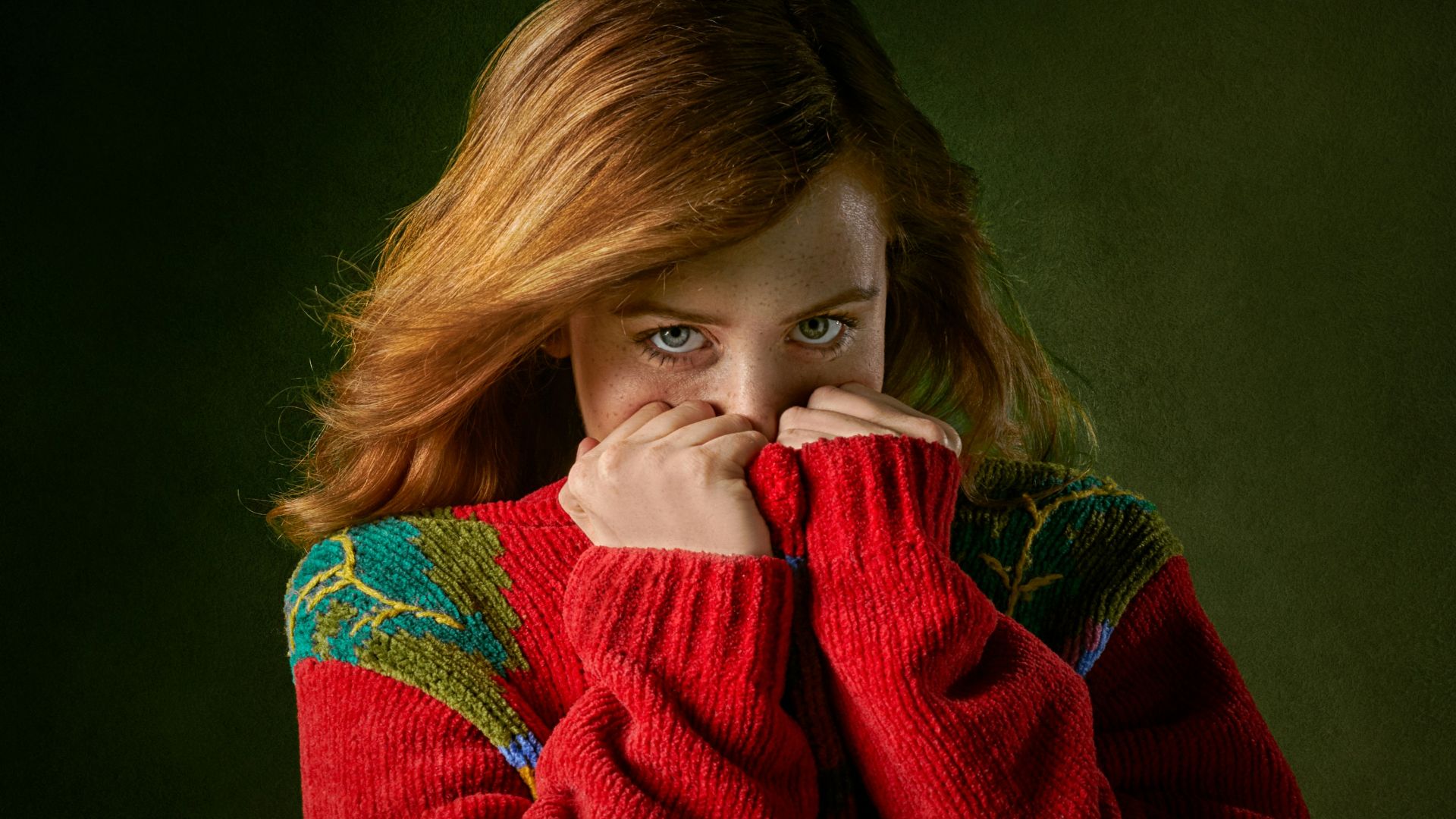 woman covering mouth with sweater