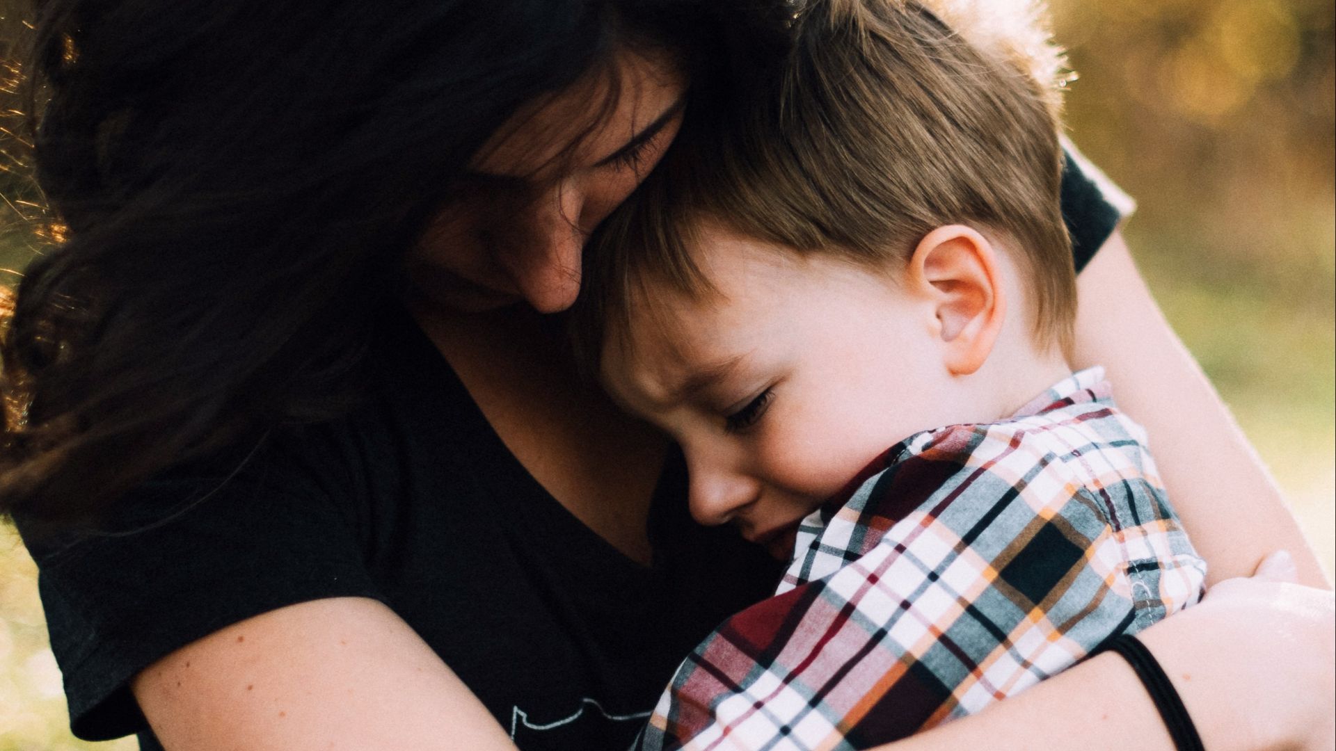 woman hugging boy on her lap